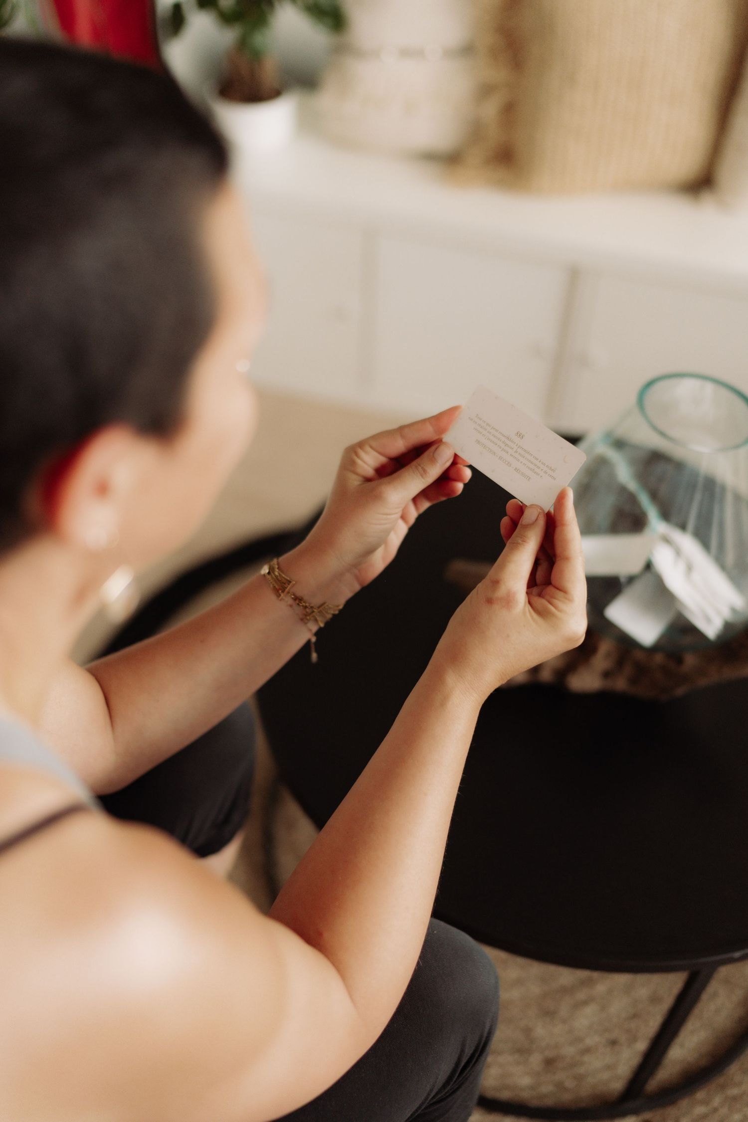A woman reads a piece of paper from a bowl