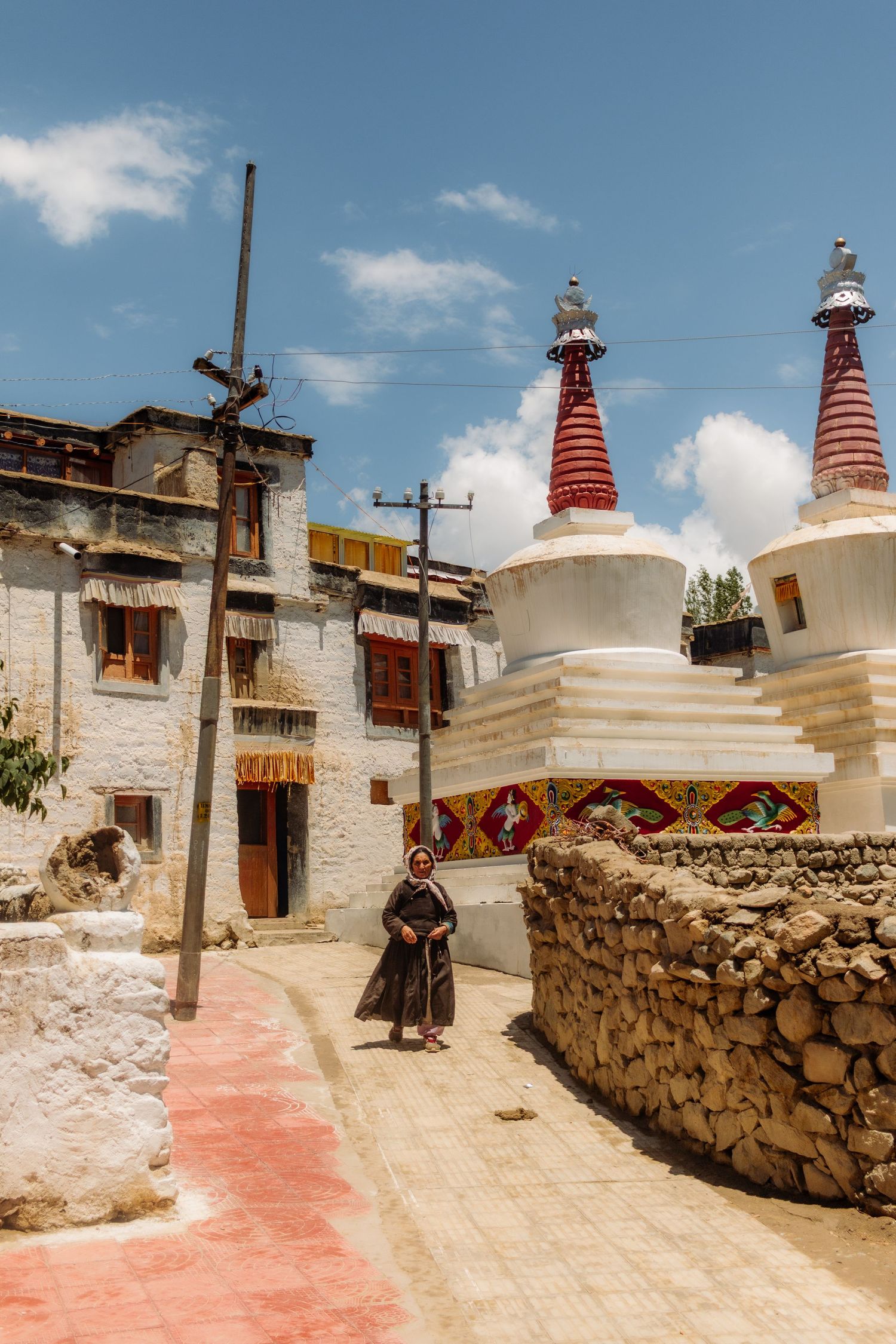 a woman walks down a temple in Ladakh, india