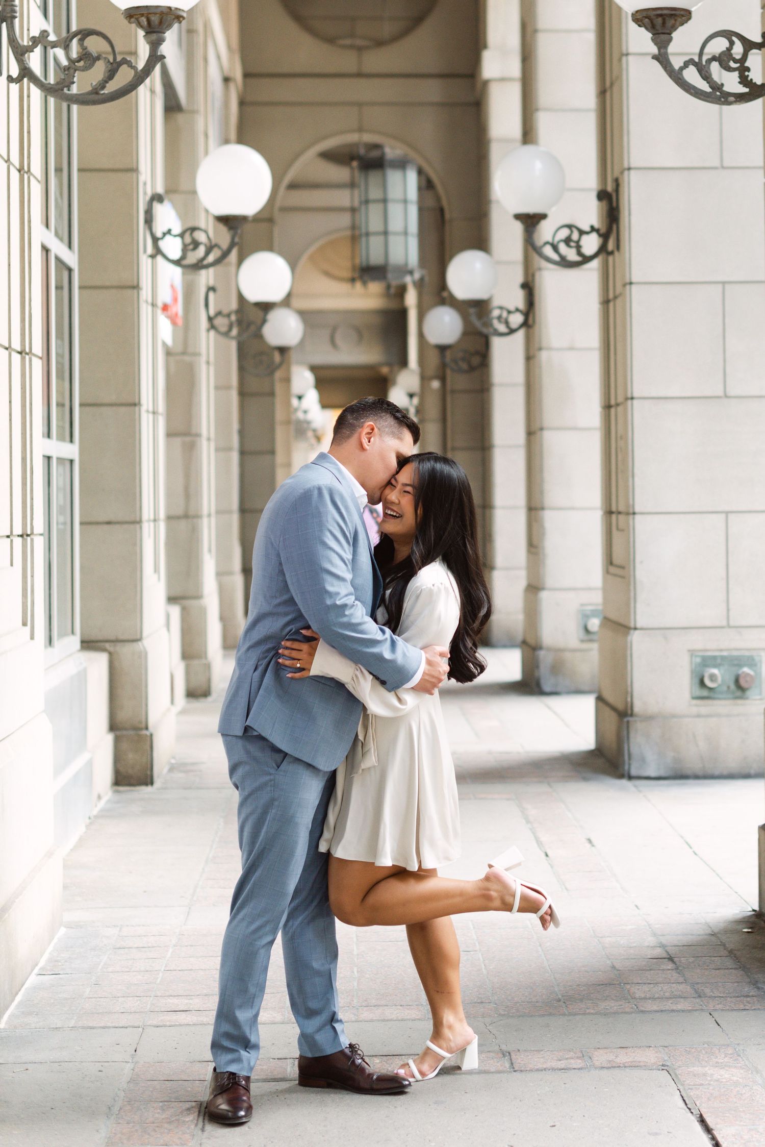Candid photo of a couple during their engagement session at The Esplanade in Toronto, photographed by a wedding photographer