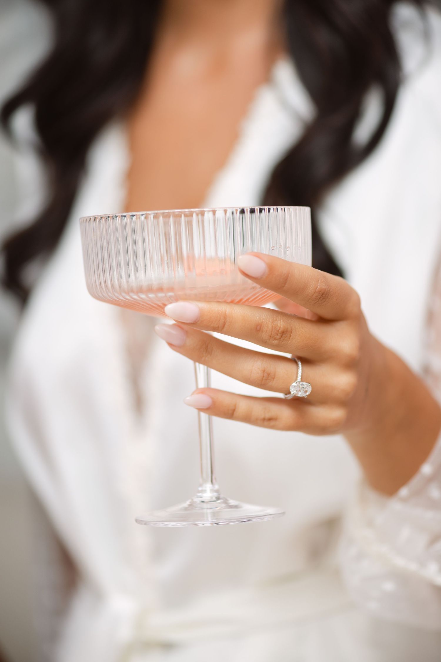 Detail photo of hand with a ring holding a champagne glass during wedding getting-ready photos, captured by a Toronto wedding photographer.