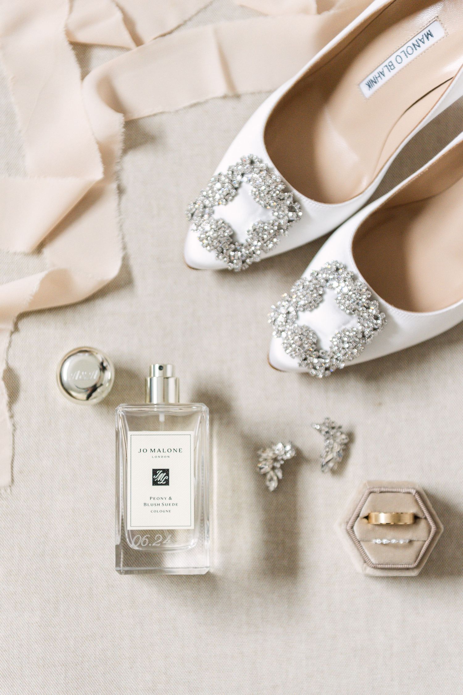 flat lay of wedding details of perfume shoes, rings, and jewelry, shot with flash by a Toronto wedding photographer