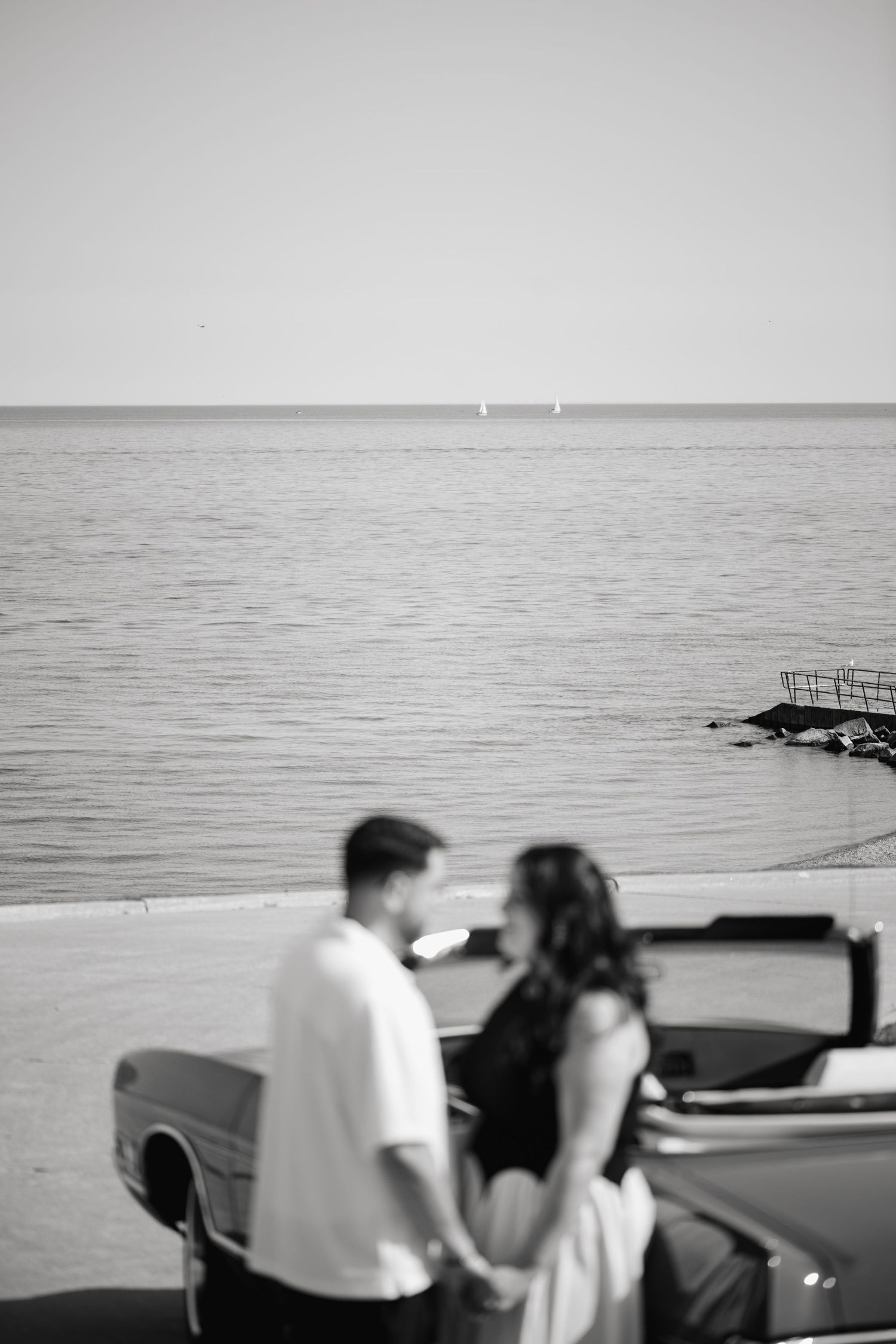 Couple engagement photoshoot at RC Harris Treatment Plant with a vintage red car by Lake Ontario, captured by a Toronto lifestyle photograph