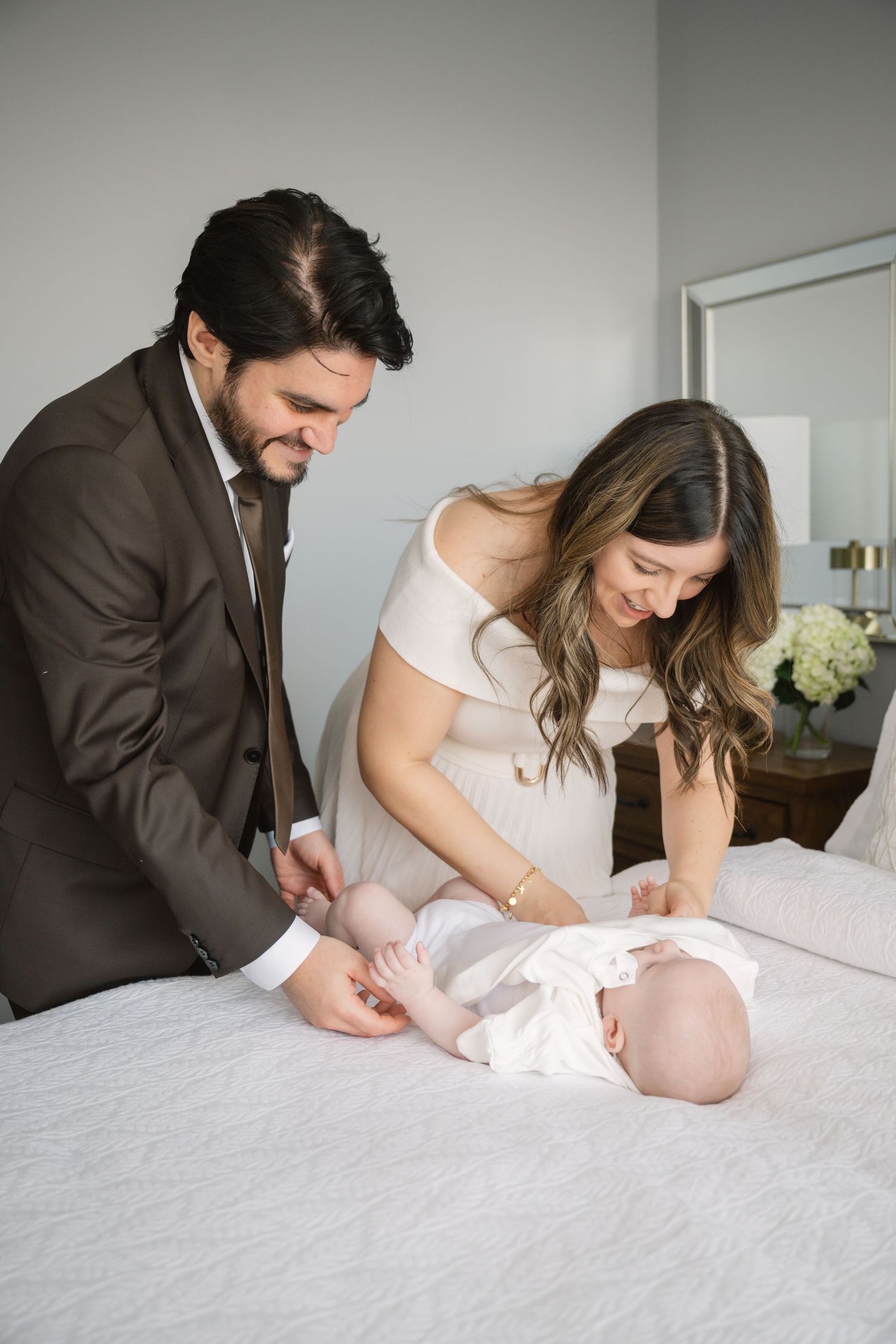 Wedding preparation scene with couple signing documents on white bedding.