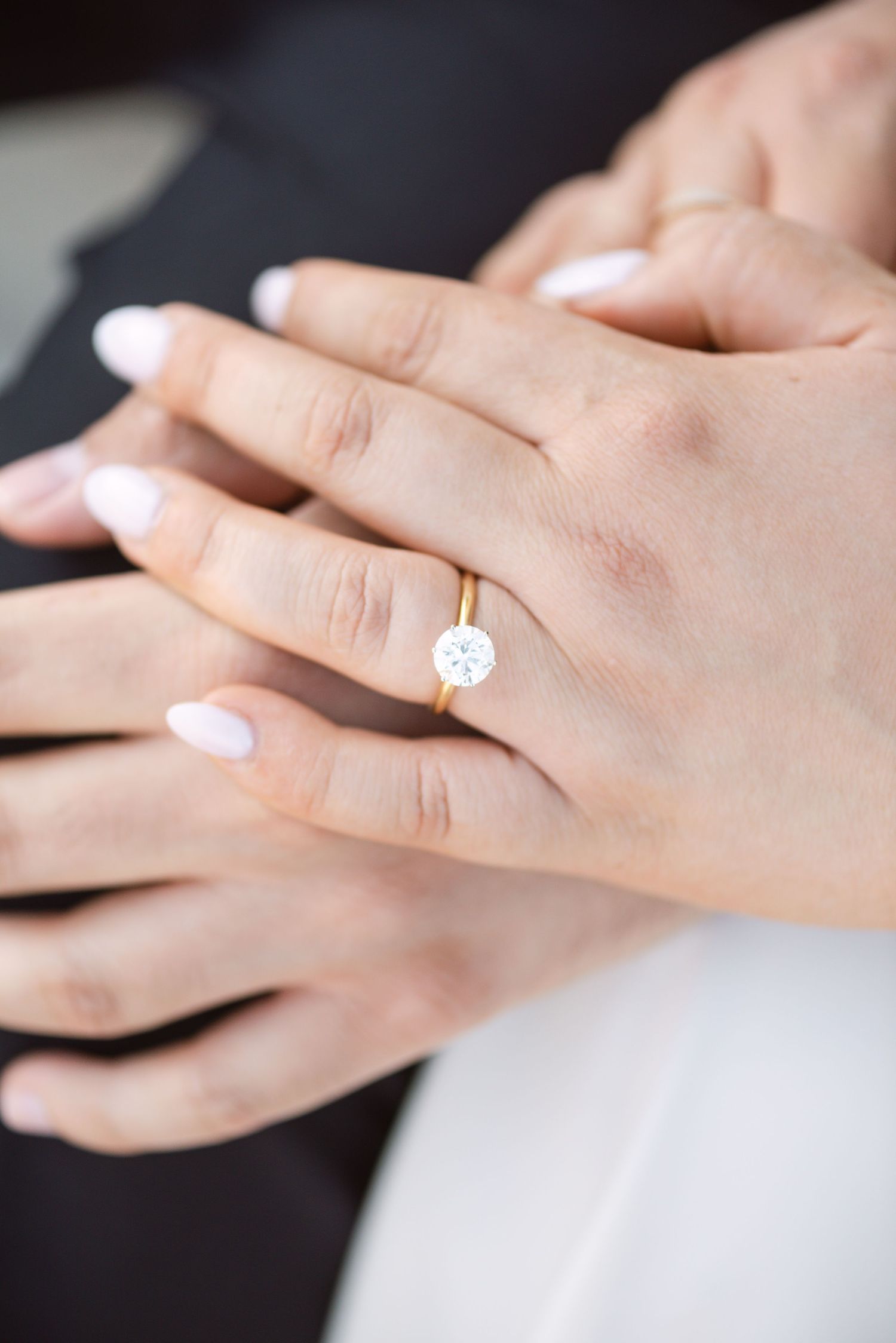 Close-up of a hand wearing a round engagement ring, photographed by a Toronto wedding and engagement photographer.
