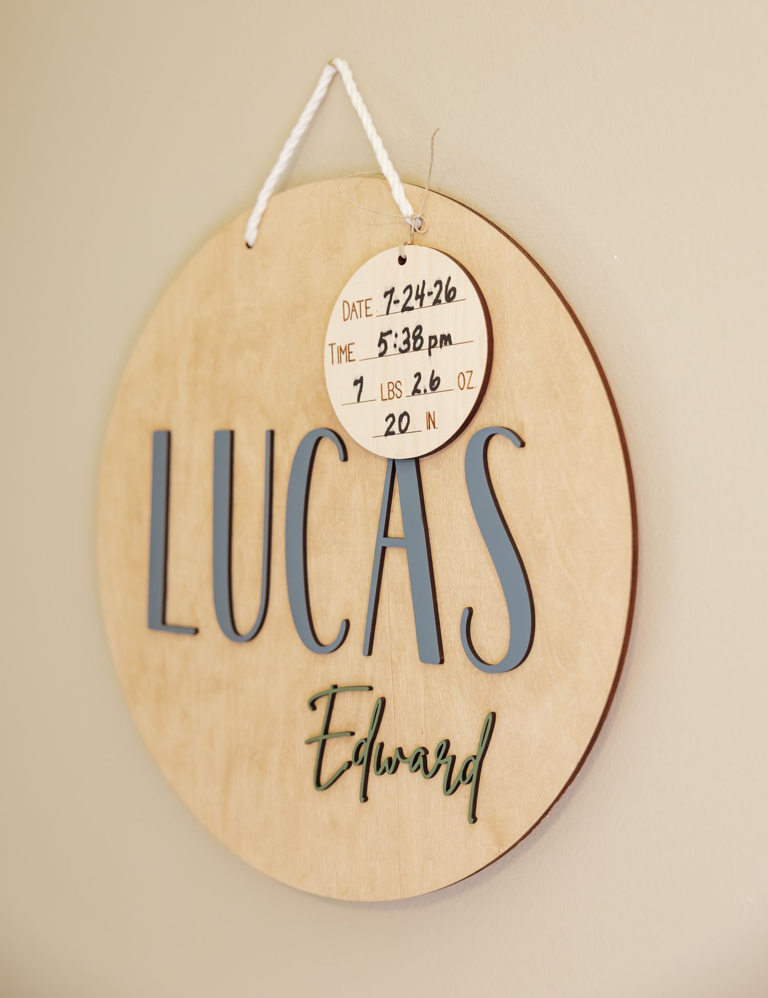 Wooden nursery name sign reading Lucas Edward with birth date 7-24-26 and stats displayed.