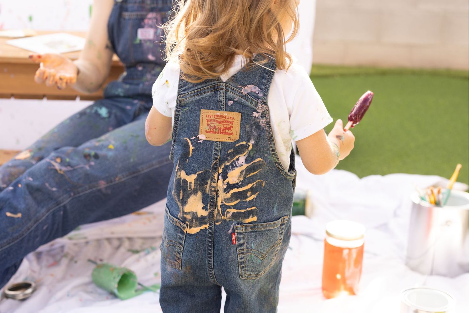 painted handprint on toddler's denim. mother daughter mommy and me playful painting photoshoot.