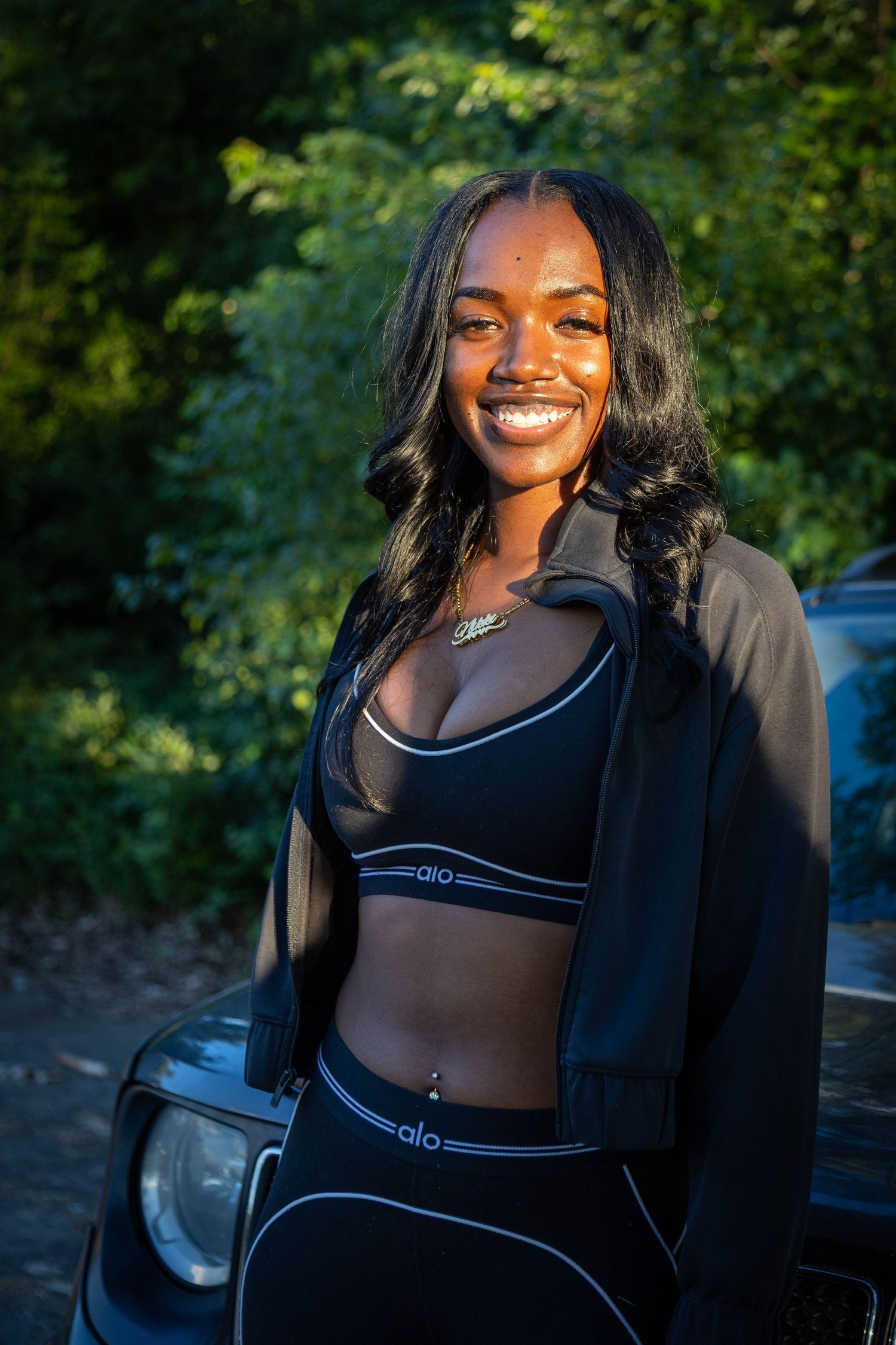 Black woman posing in front of car