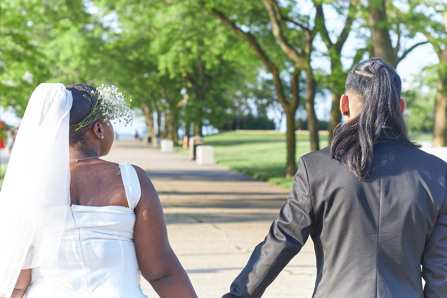 Married couple holding hands looking away