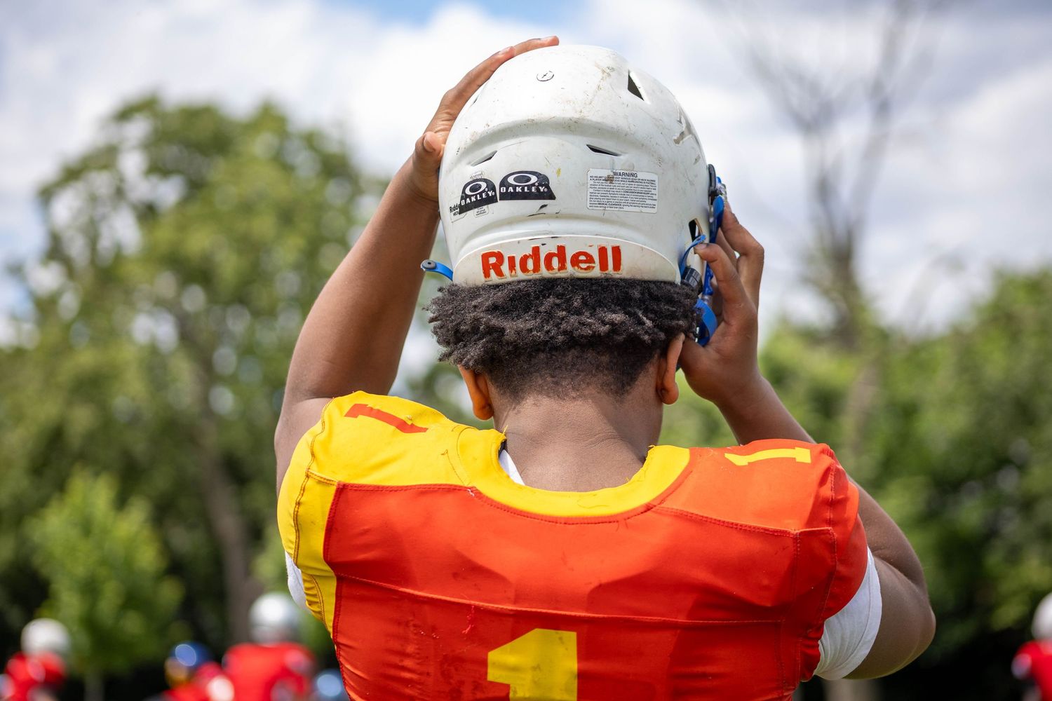 Football player putting on helmet