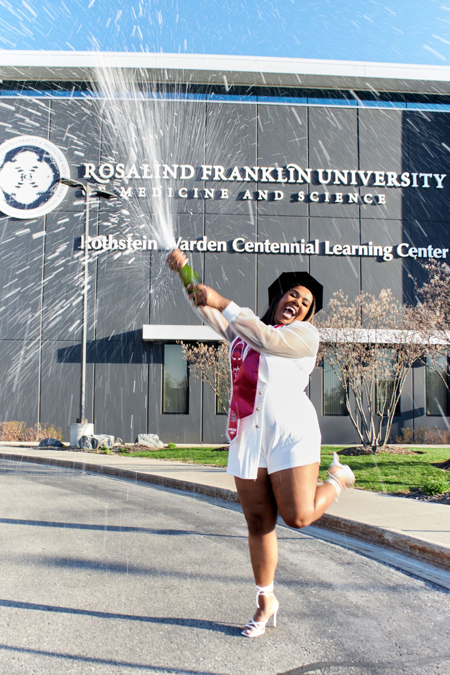 Graduate popping champagne bottle