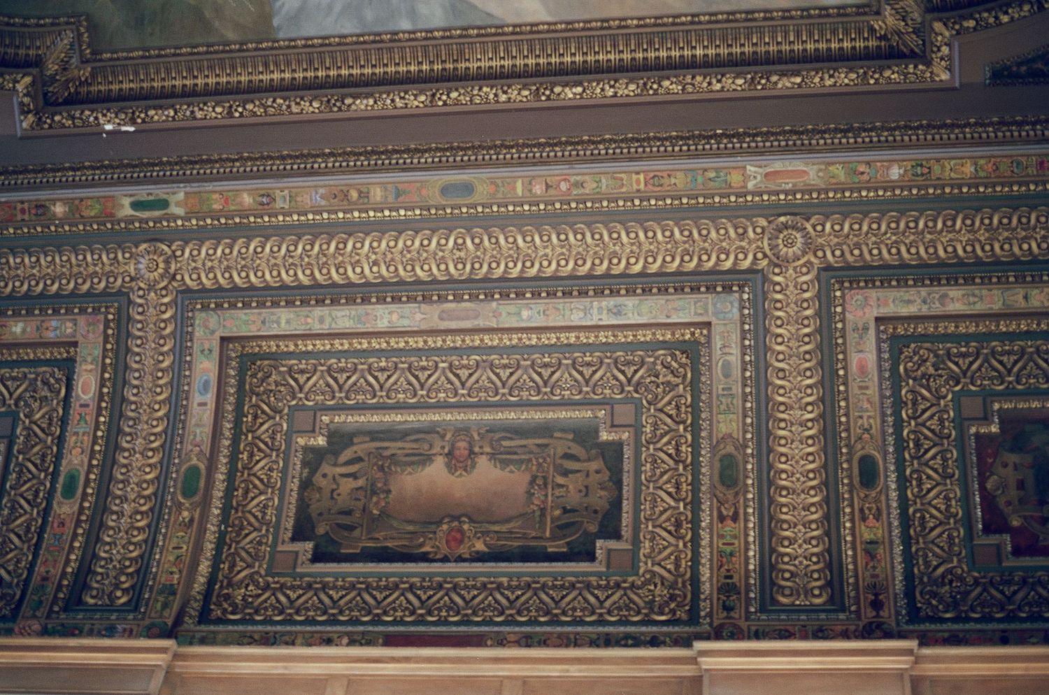 Ornate gilded ceiling with intricate mosaic patterns and classical painted panels in historic building.
