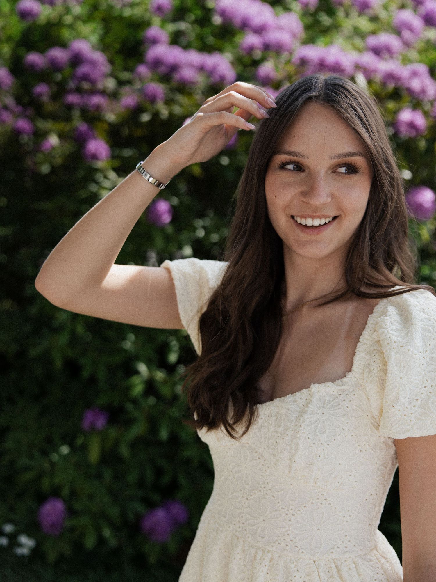 Social Media Content Creation: Lächelnde Frau im hellen Sommerkleid vor Blumen – Social Spark, deine Marketing-Agentur in Rottal-Inn