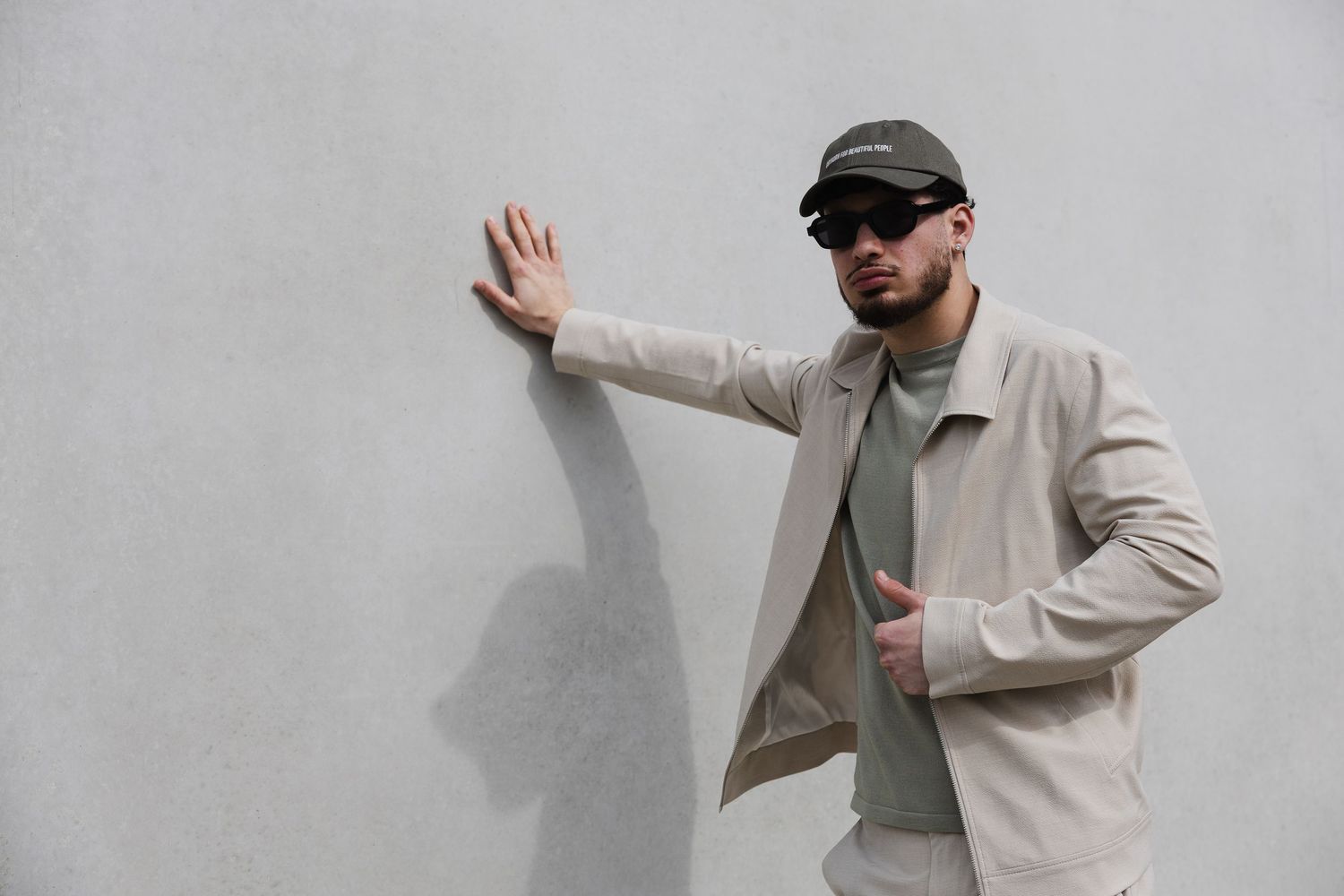 Social Media Content Creation: Mann in hellem Streetwear-Outfit vor grauer Wand – Social Spark, Marketing-Agentur in Rottal-Inn.