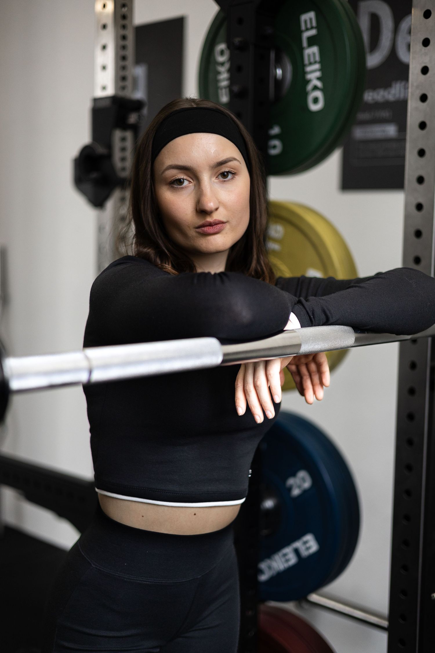 Content Creation für Fitness & Gyms: Sportlerin lehnt an einer Langhantel im Squat Rack – Social Spark, Marketing-Agentur, Rottal-Inn