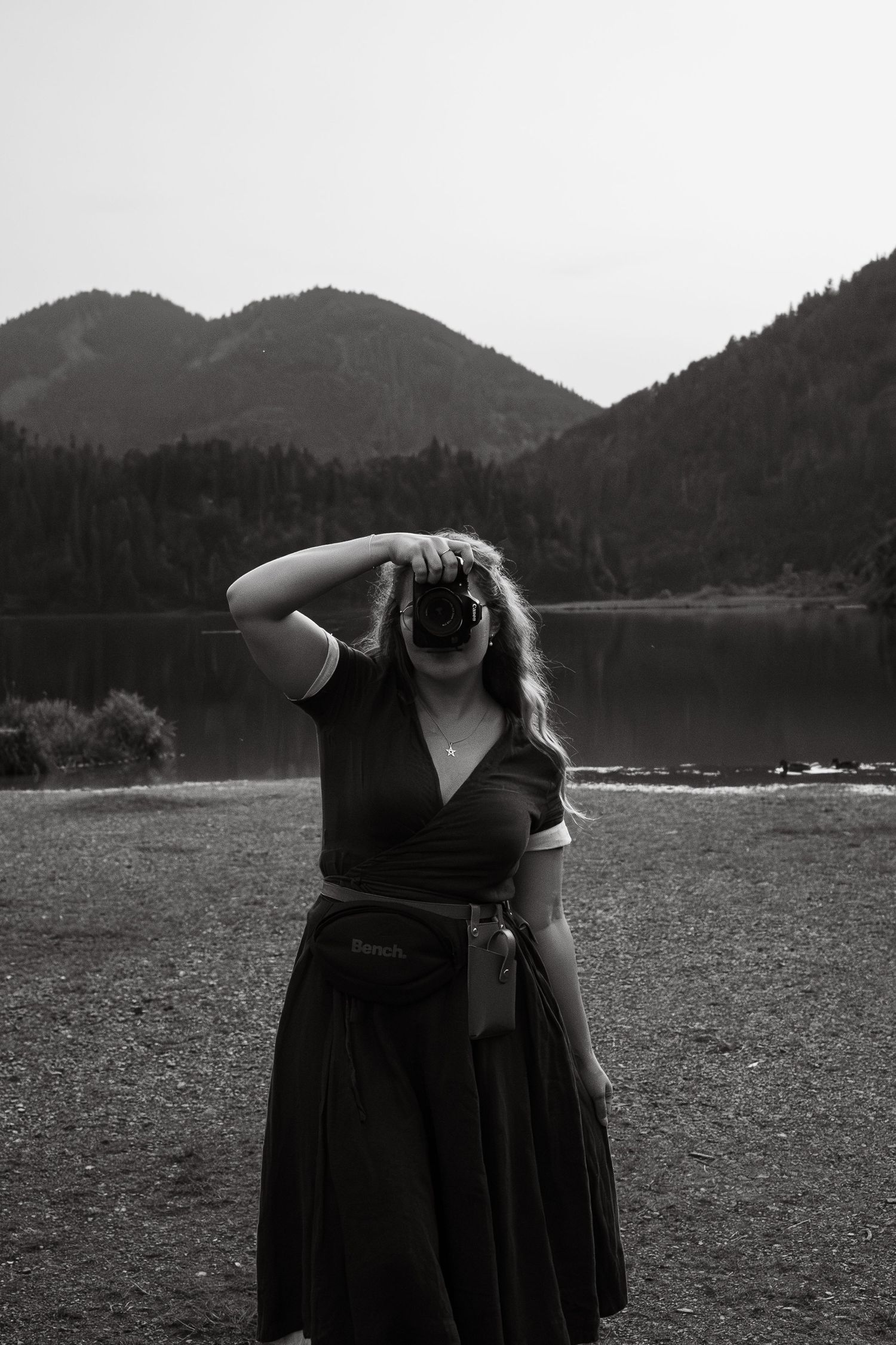 Fotografin Ella vor Bergkulisse in Schwarz-Weiß: Social Media Content Creation von Social Spark für Rottal-Inn, Bayern.
