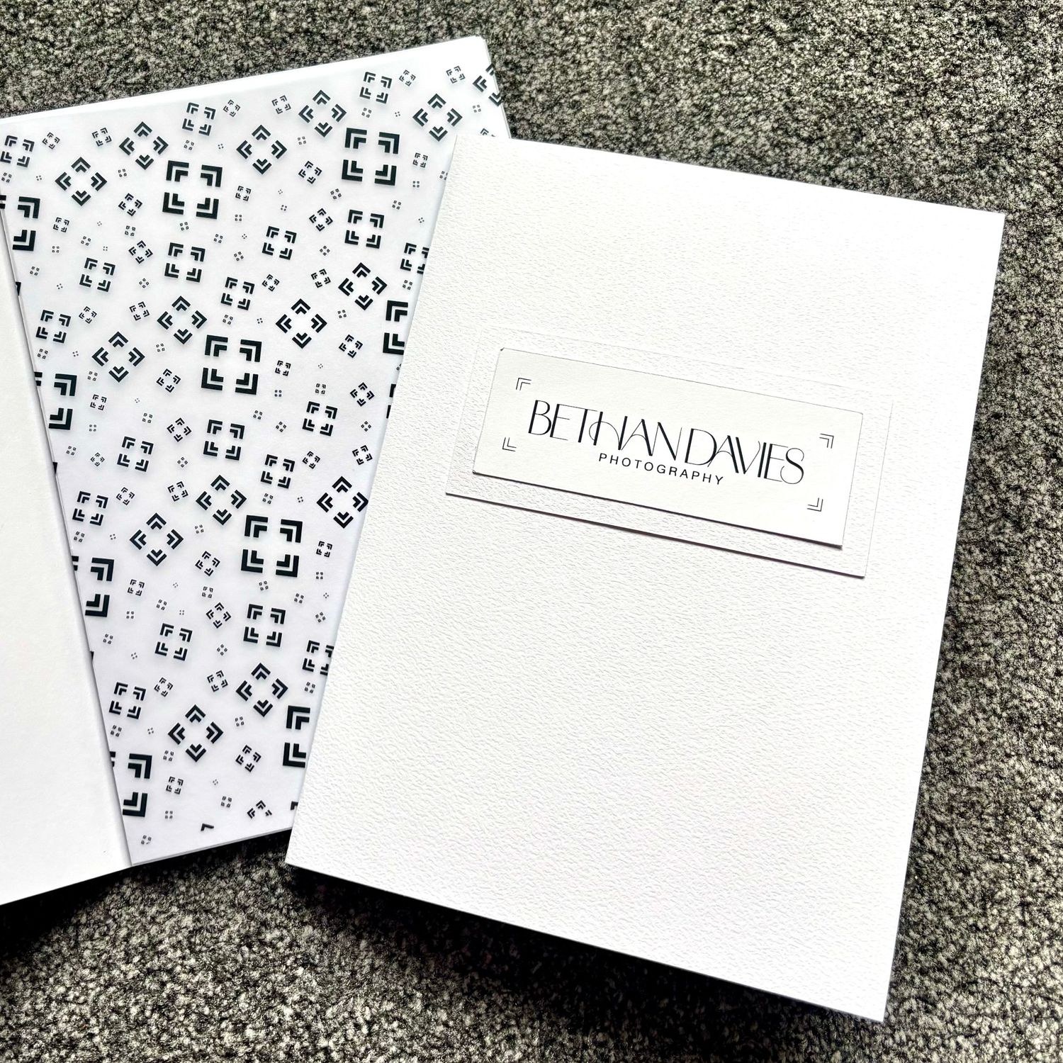 White photography portfolio folder with Bethan Davis Photography logo, paired with decorative patterned tissue paper insert.