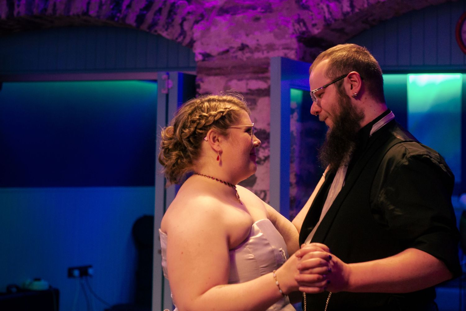 Couple sharing a romantic dance at a wedding reception, bride in white dress and groom in black shirt at the storehouse, kirkwall