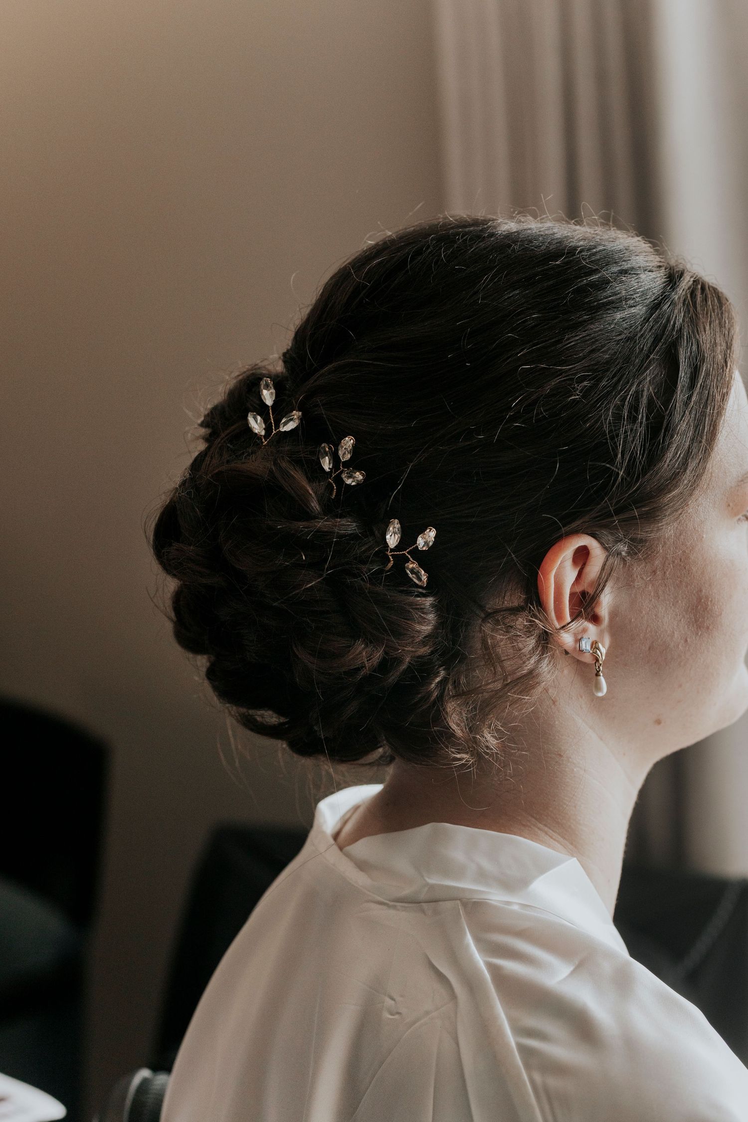 An elegant updo hairstyle adorned with delicate crystal hair accessories.