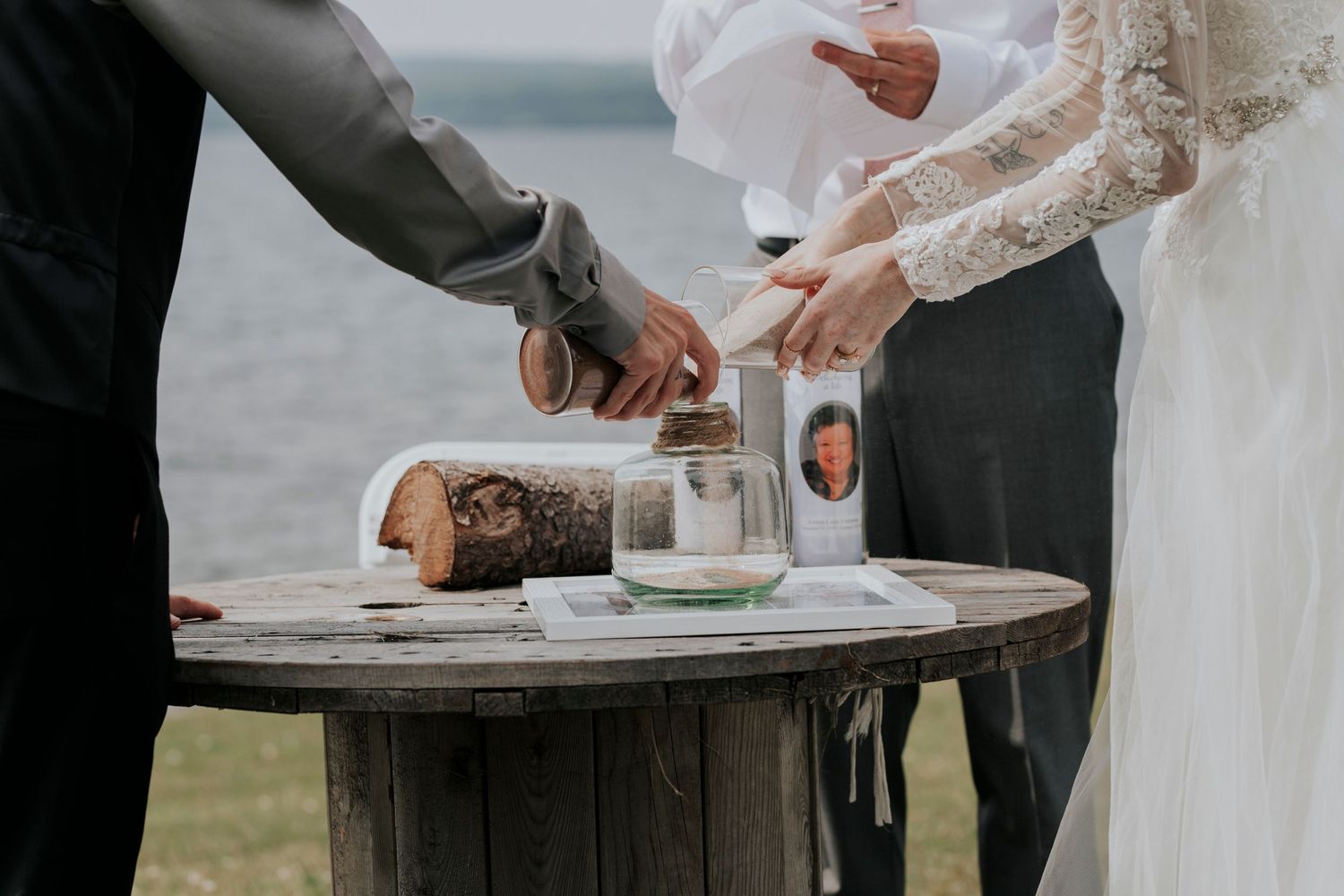 A couple performs a sand ceremony during their lakefront wedding in Cape Breton, NS