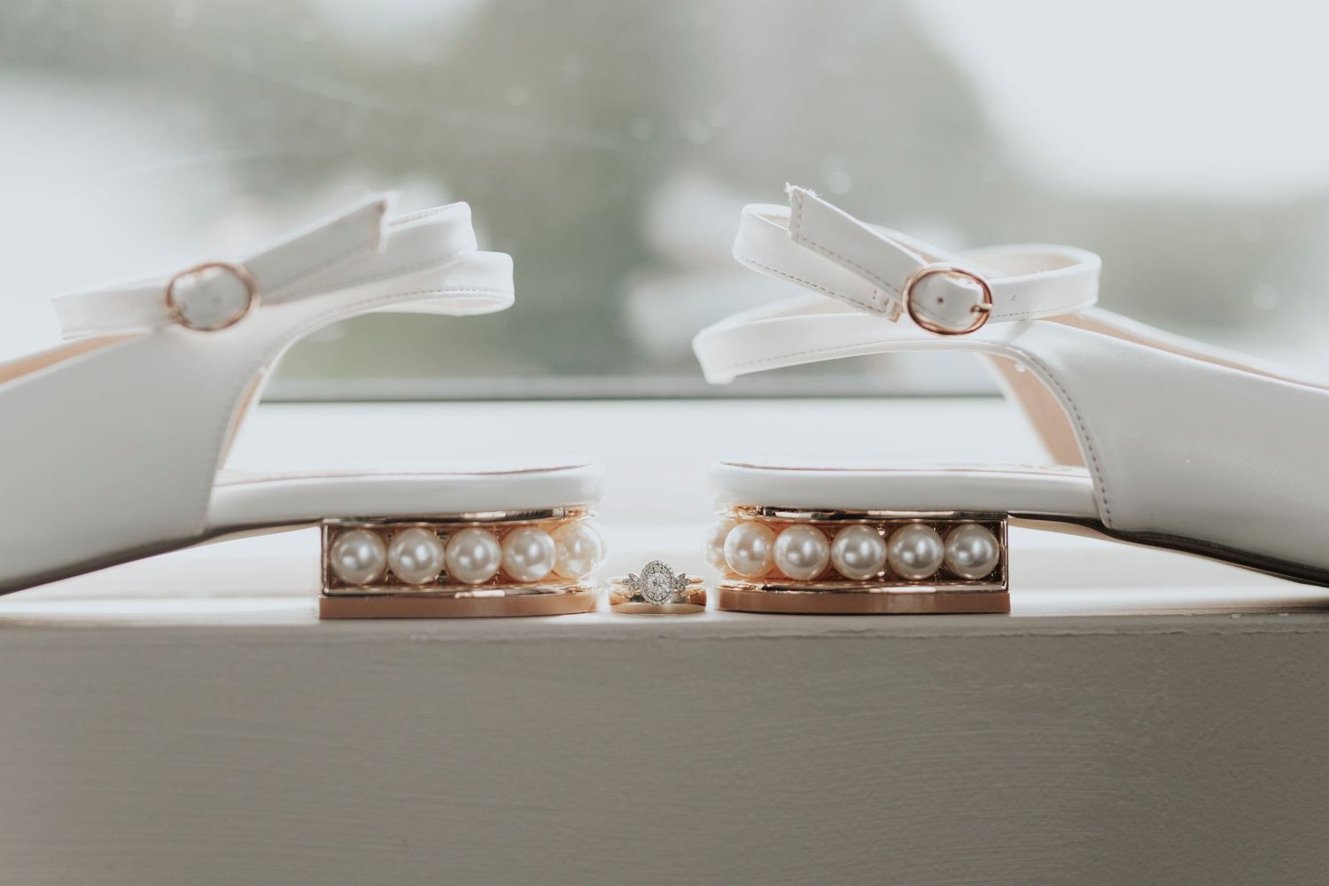 Wedding rings displayed elegantly on white clips with diamonds and bands visible.