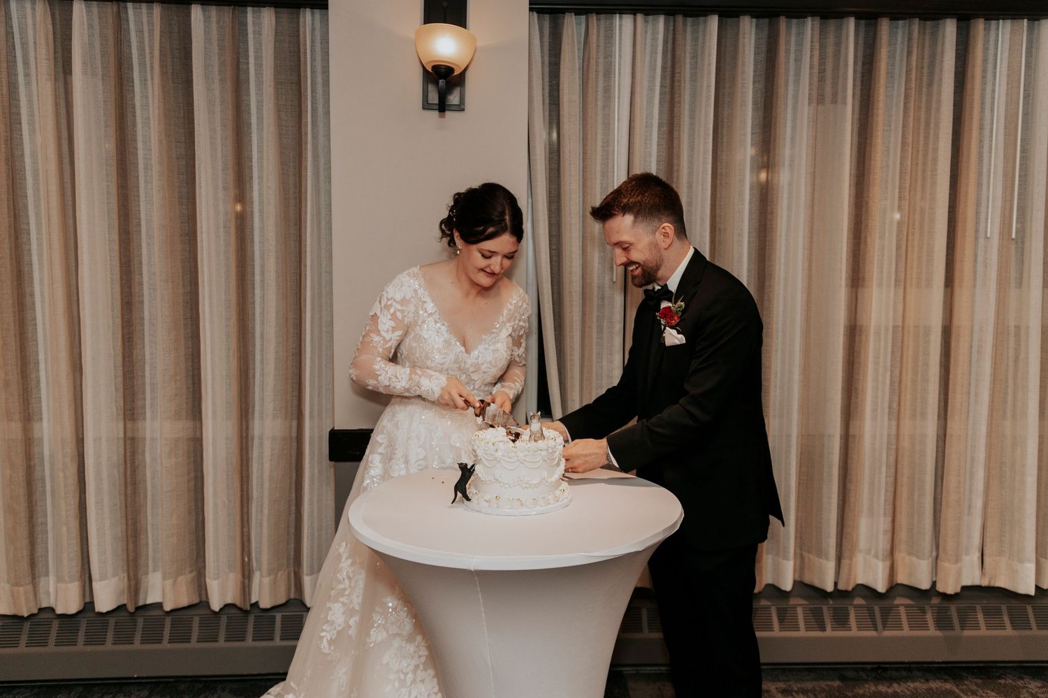 Couple signing their wedding documents at a white cocktail table.