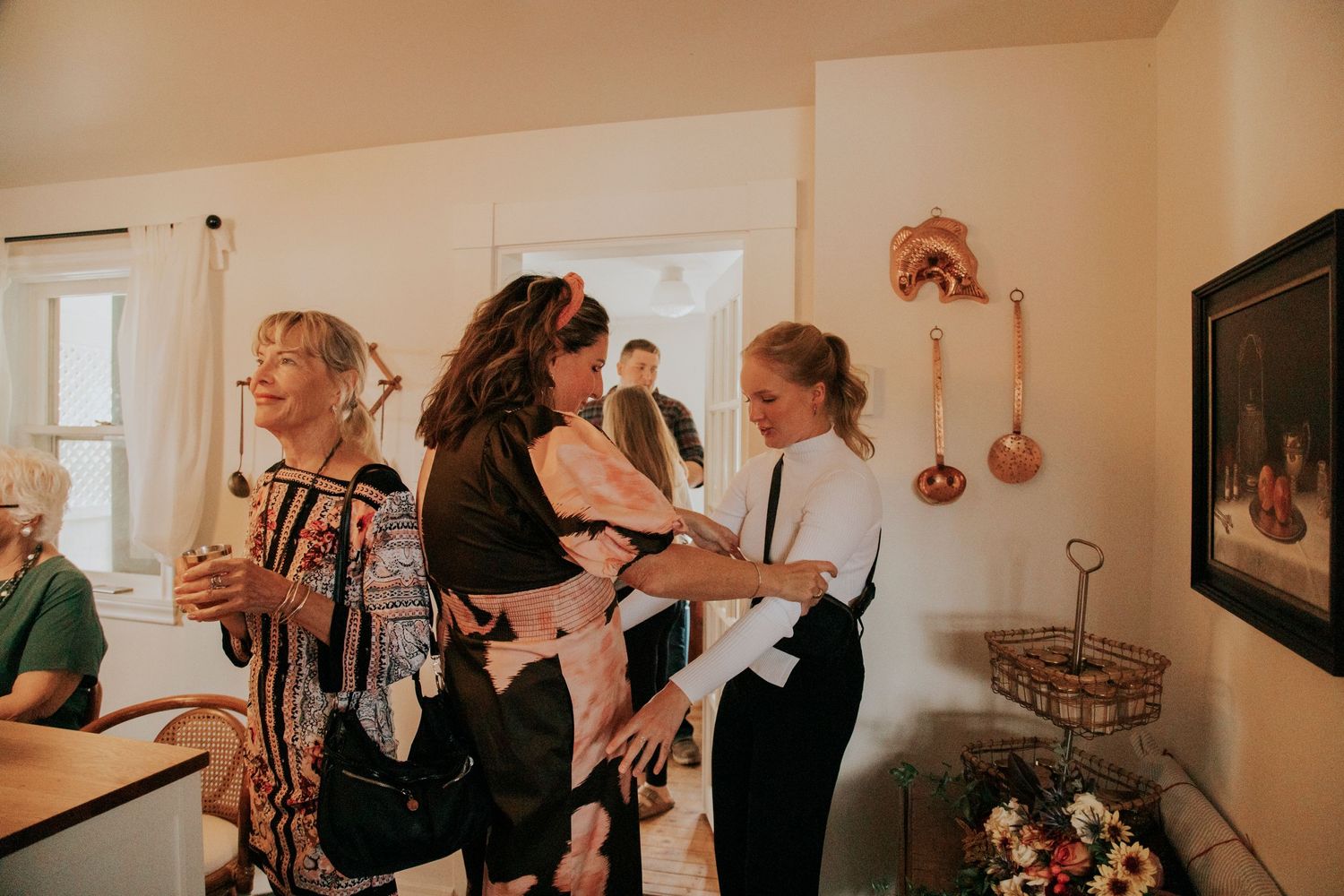 People gather in a warmly lit indoor space with vintage decor, creating a cozy and intimate atmosphere.