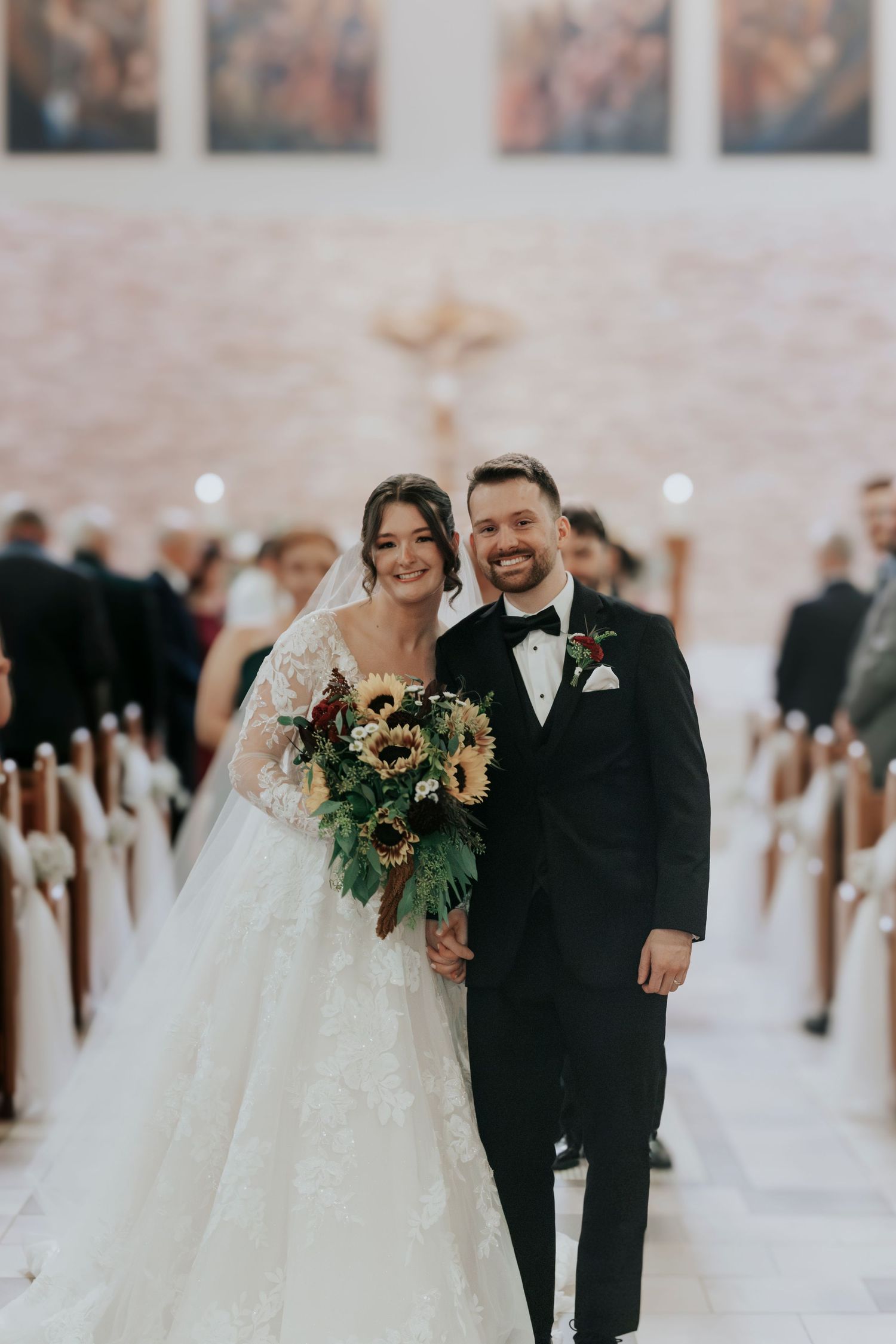Wedding ceremony in church with stone accent wall and religious artwork.