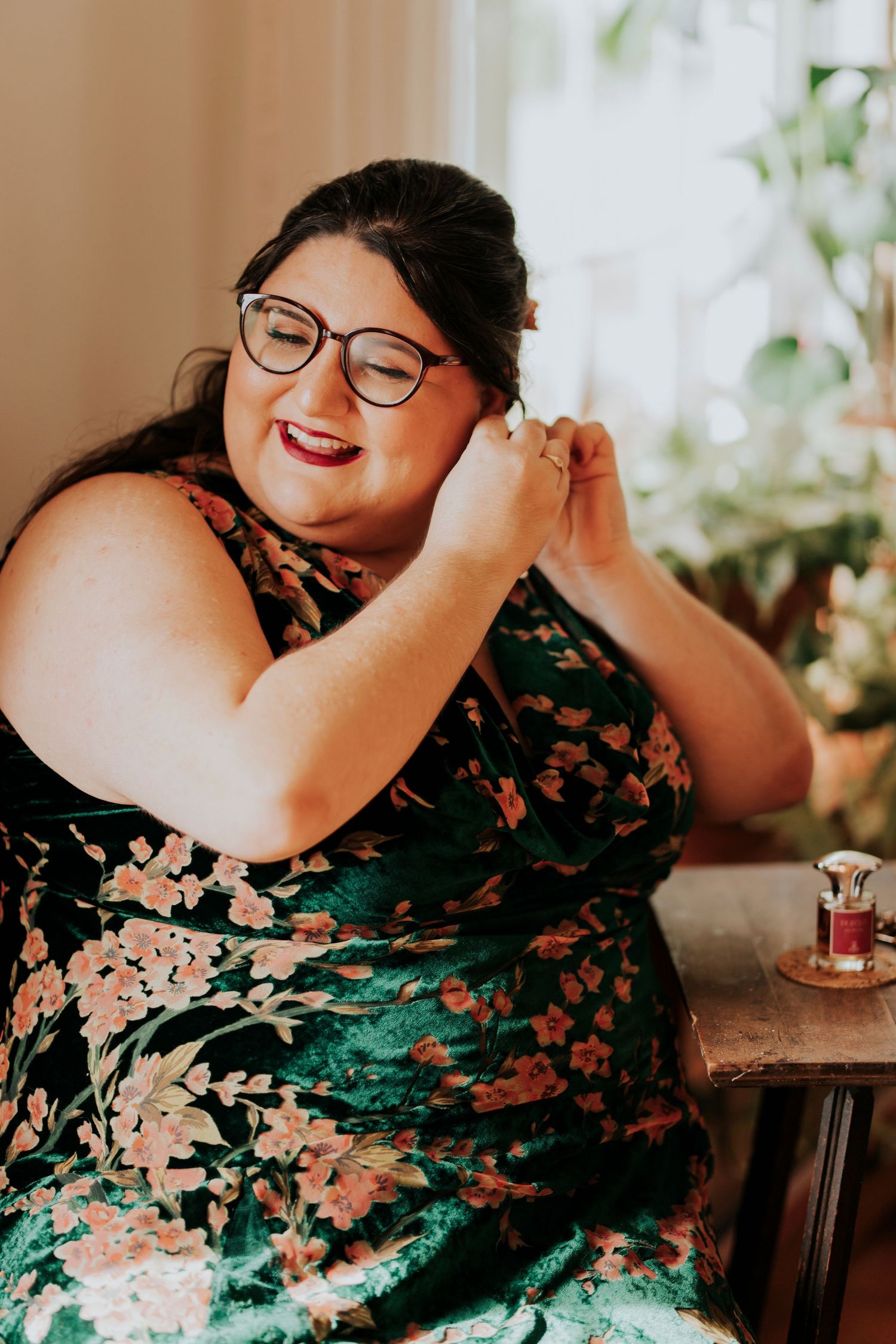a bride puts earrings on the morning of her wedding