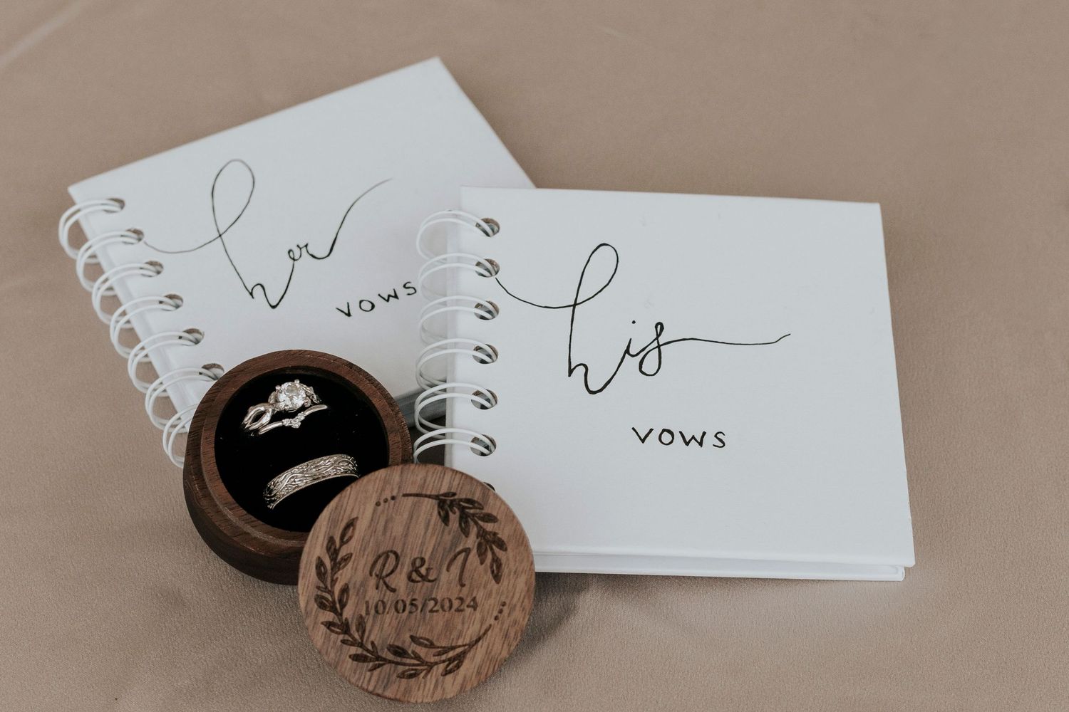 His and her vow books with a wooden ring box engraved with initials and wedding date.