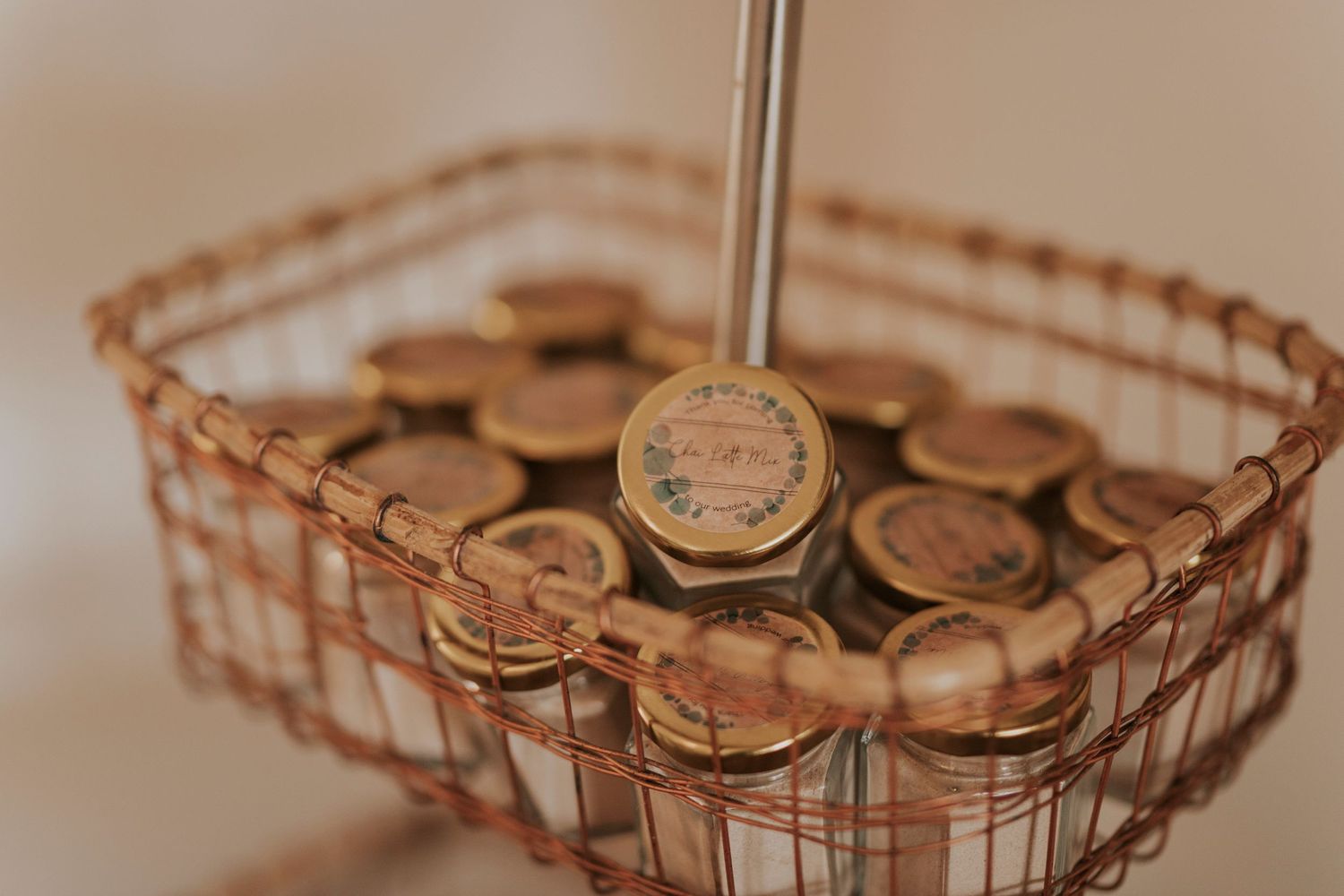 Mason jar lids arranged in a rustic copper wire basket creating a vintage and rustic wedding favour.