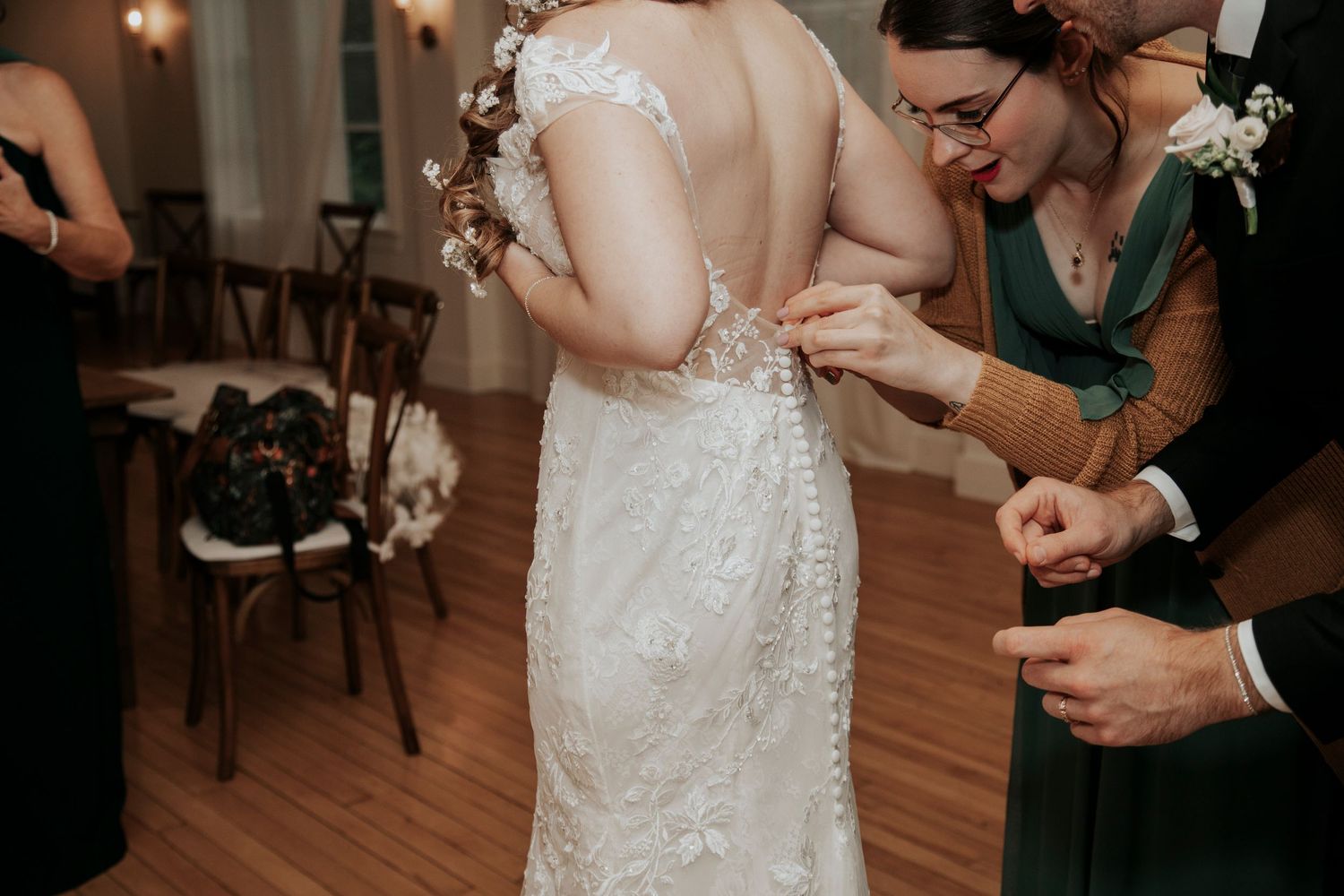 Close up of wedding dress details being adjusted during preparation.