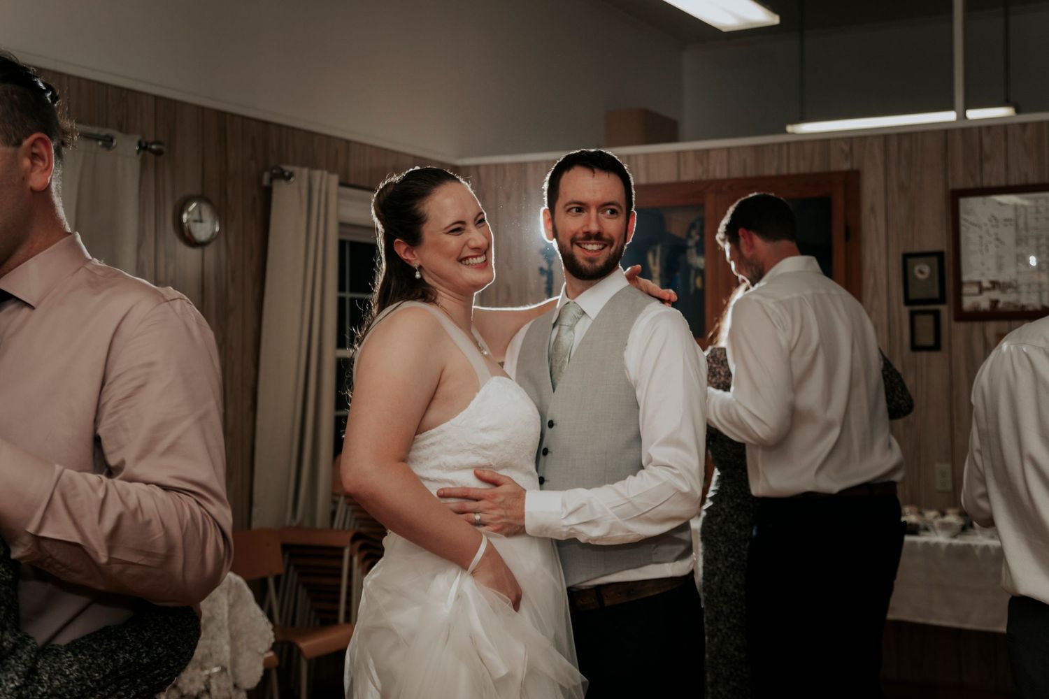 Bride and groom sharing a dance together at their wedding reception in a warmly lit venue.
