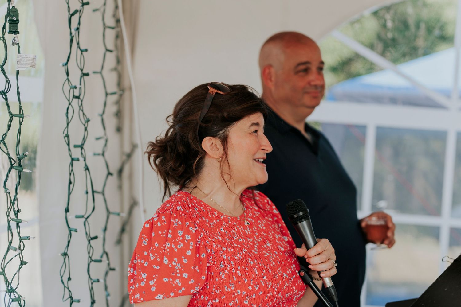 Wedding speeches during a summer wedding under a tent.