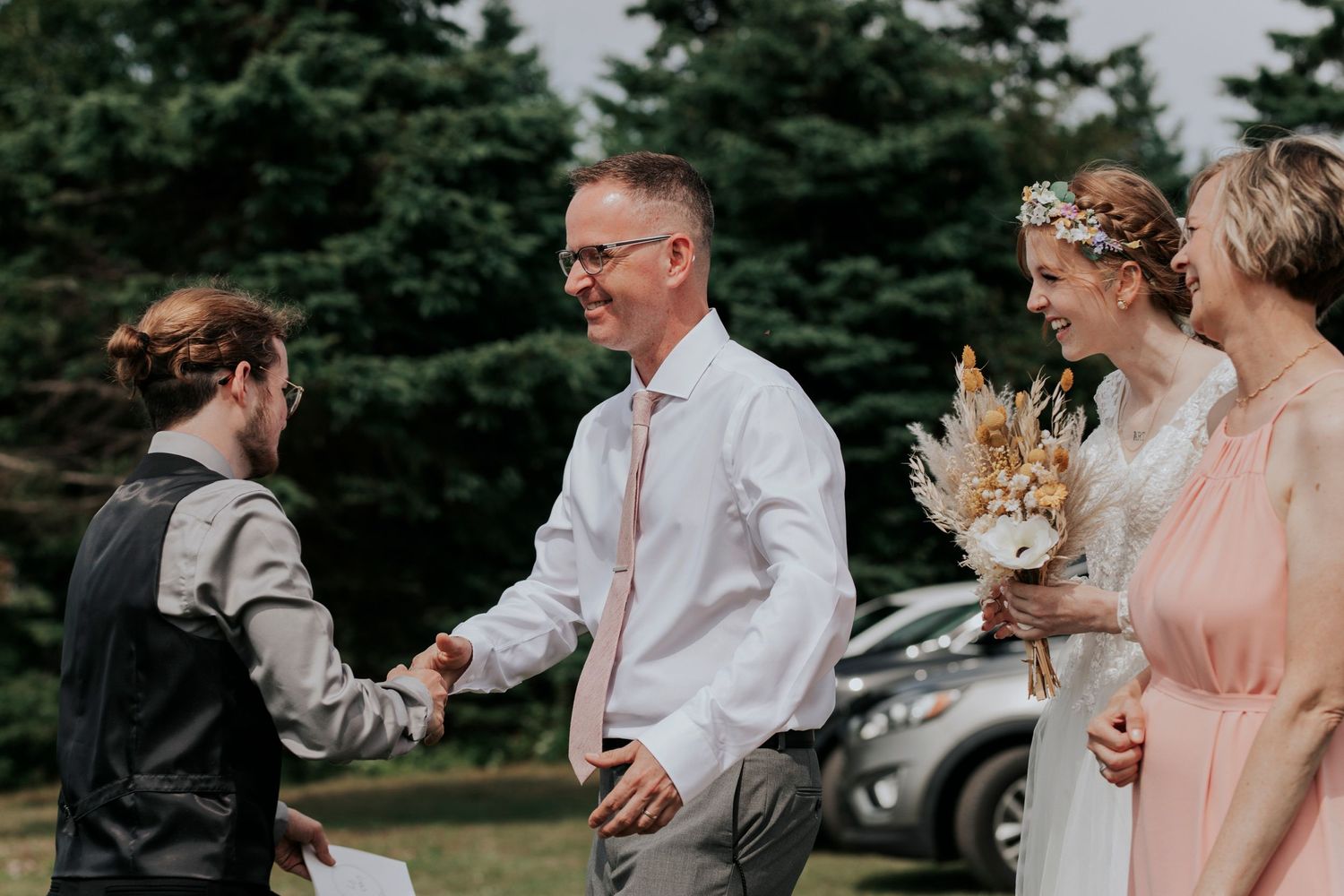 The father of the bride meets his new son-in-law at the end of the isle as he gives his daughter away.