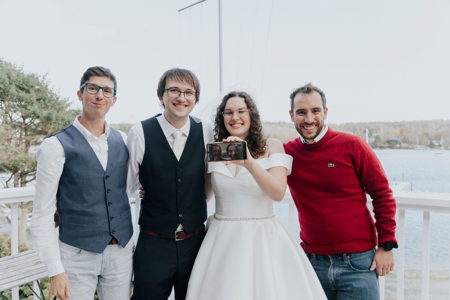 Group celebrating special occasion together on waterfront deck in formal attire.