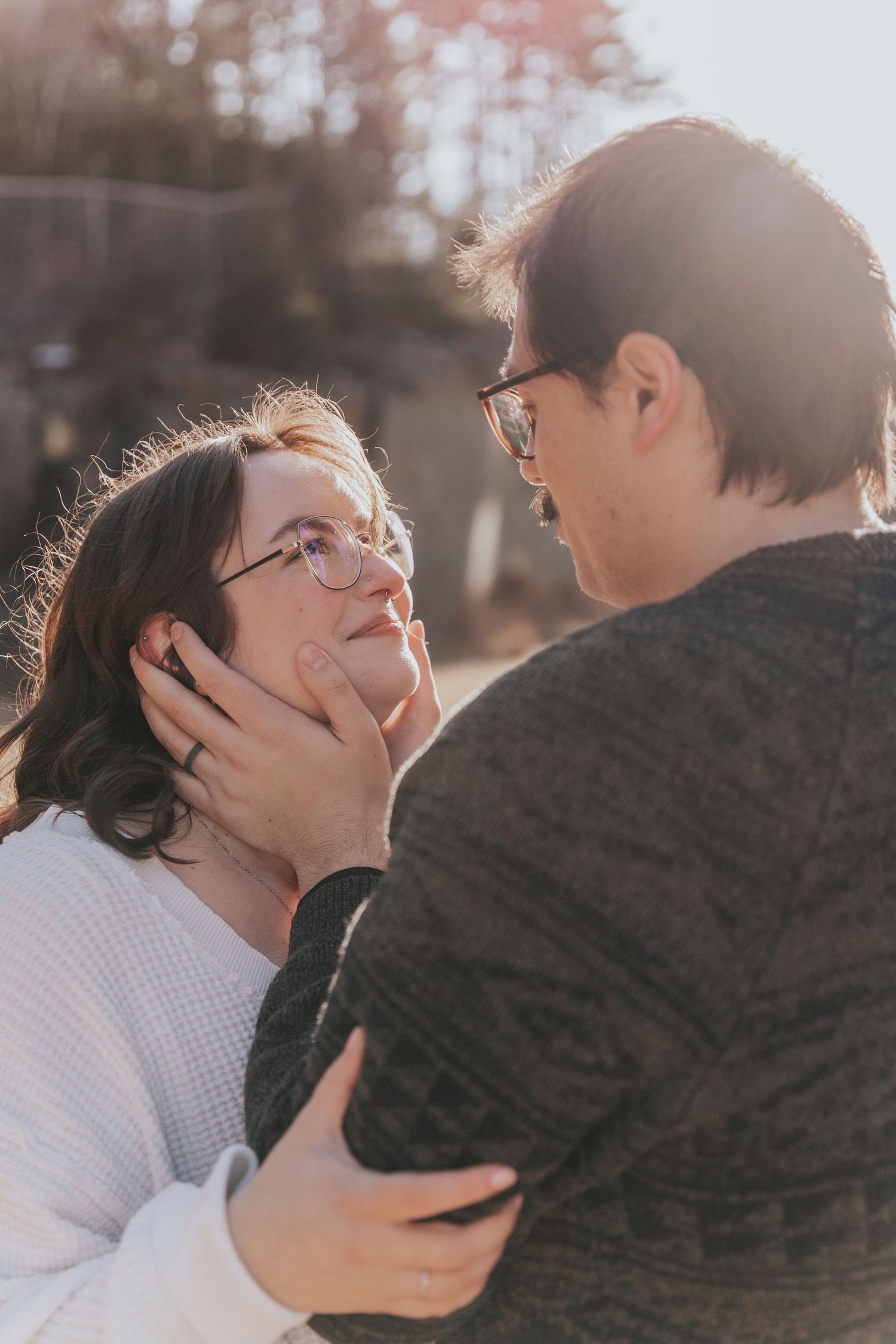Close-up of couple gazing into each other eyes with warm golden backlight at sunset.