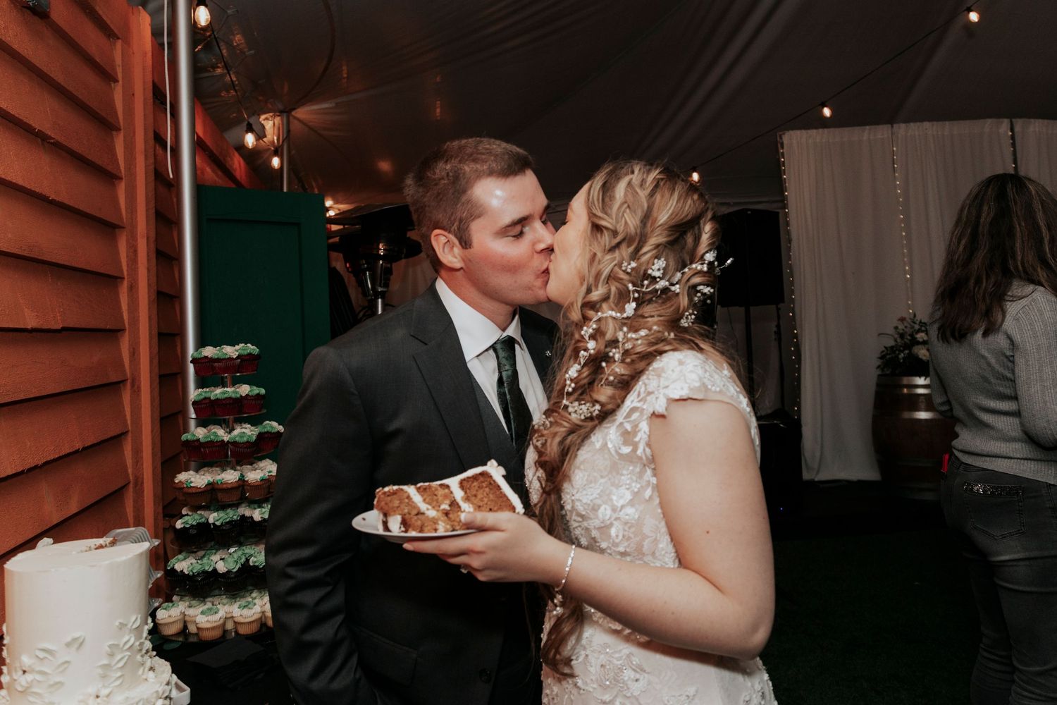A couple in wedding attire share their first taste of wedding cake together at their reception.