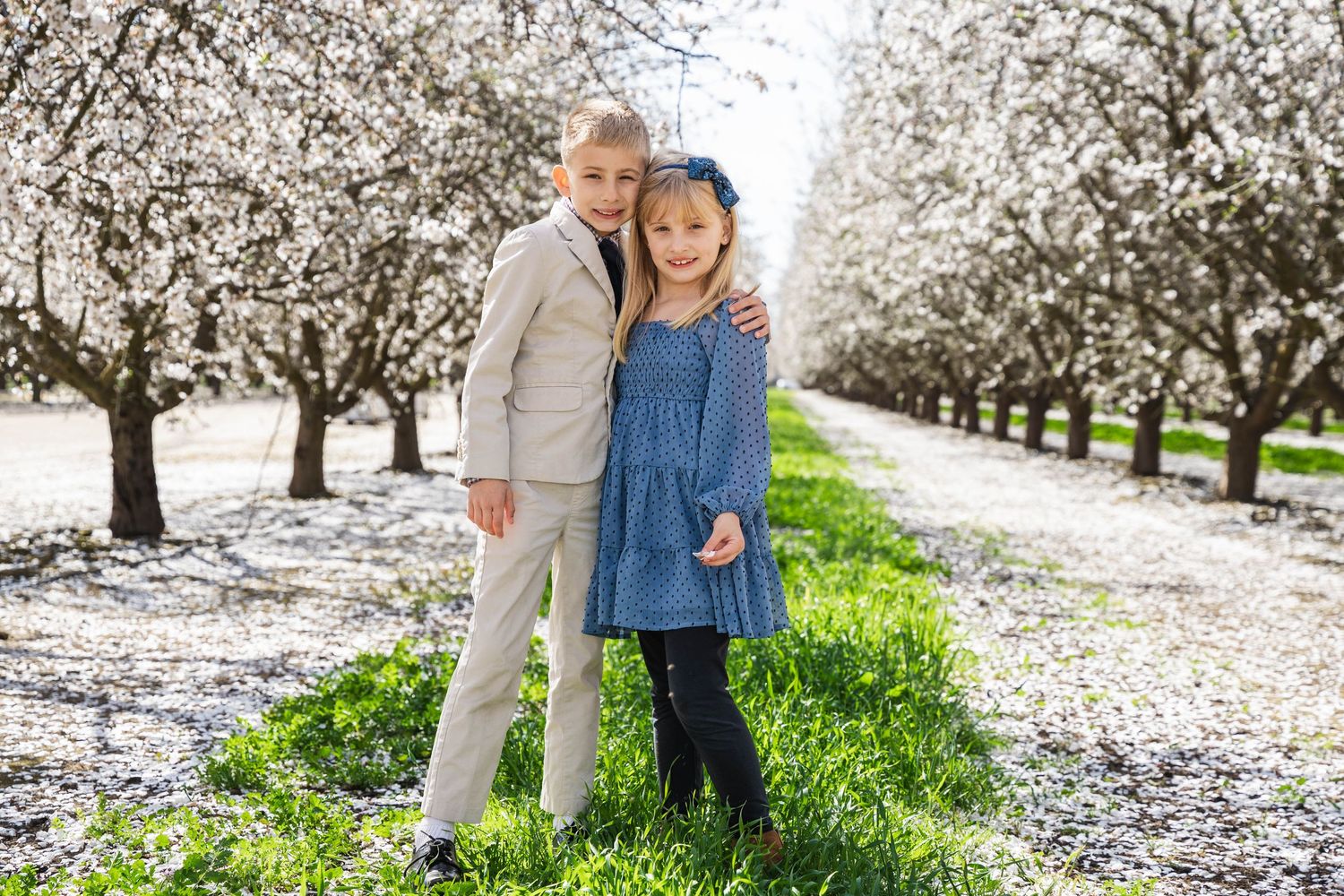 Young kids visiting almond orchards in bloom