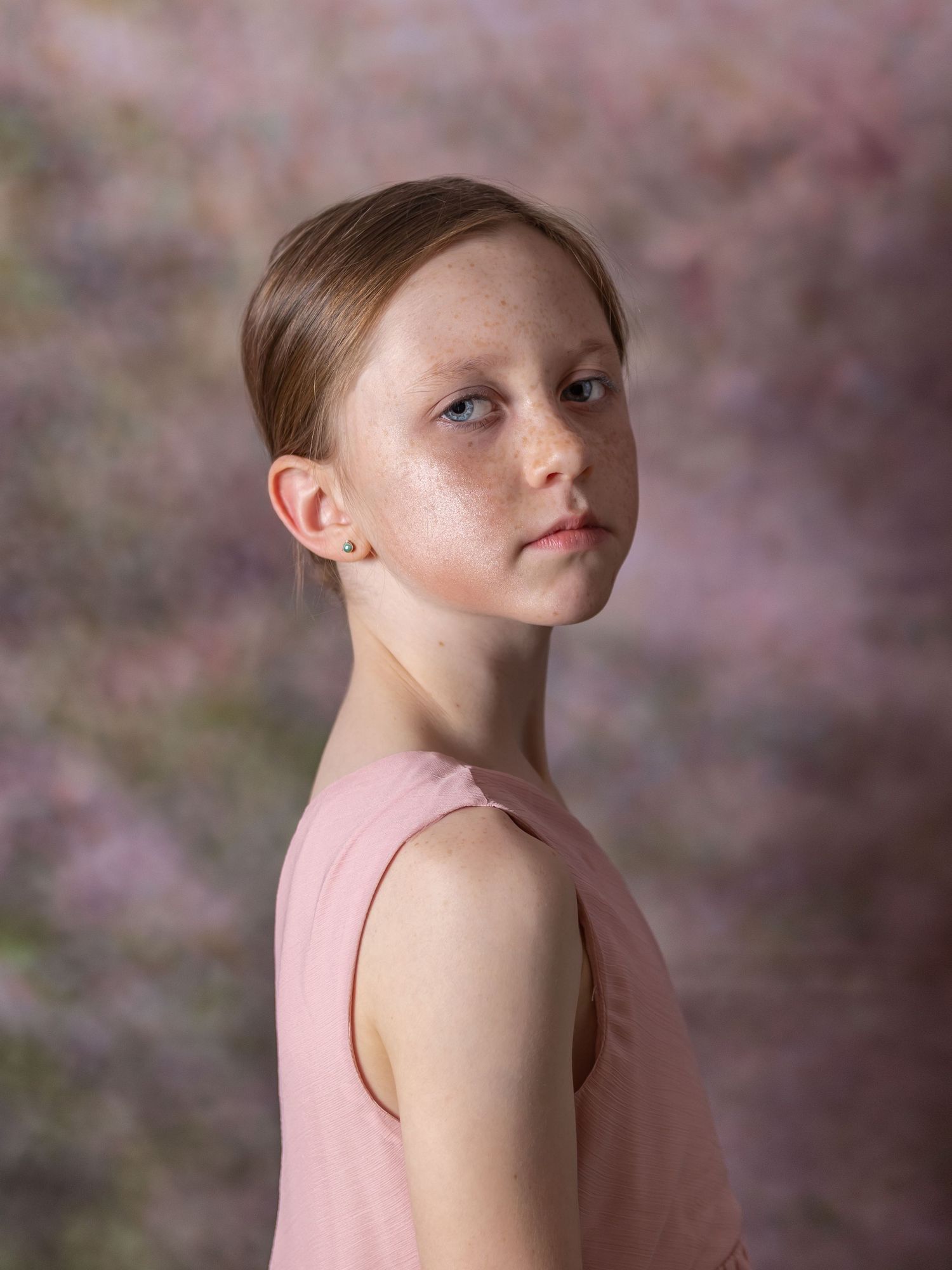 Studio portrait with soft lighting and pink tones capturing youth and innocence.