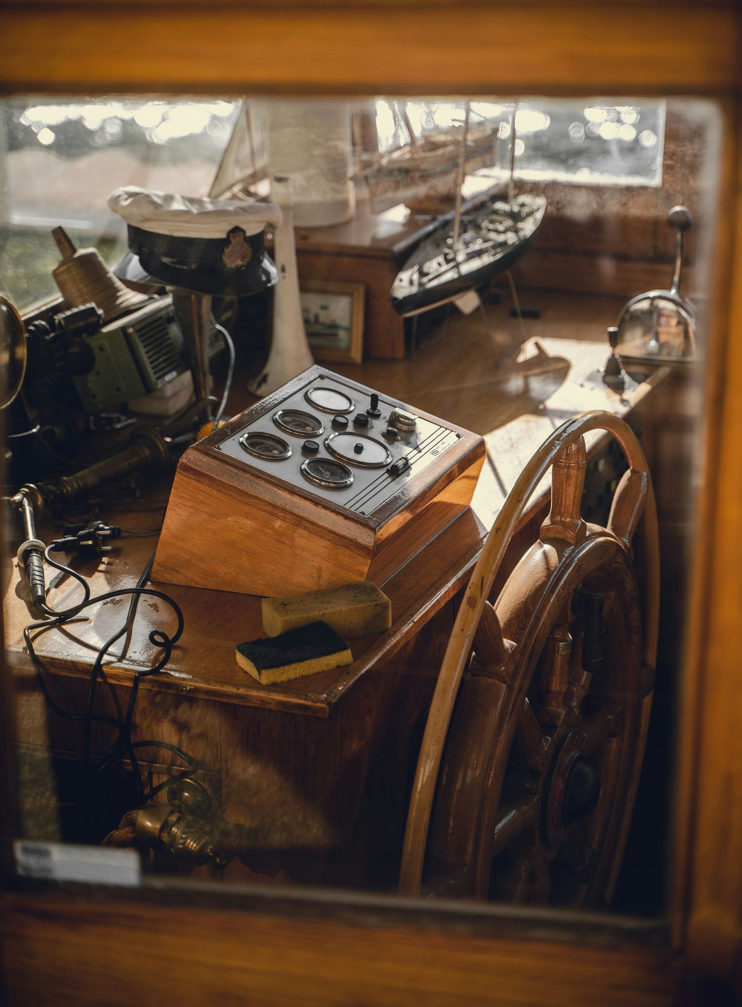 Vintage phonograph record players and antique audio equipment displayed on wooden tables in a museum-like setting.