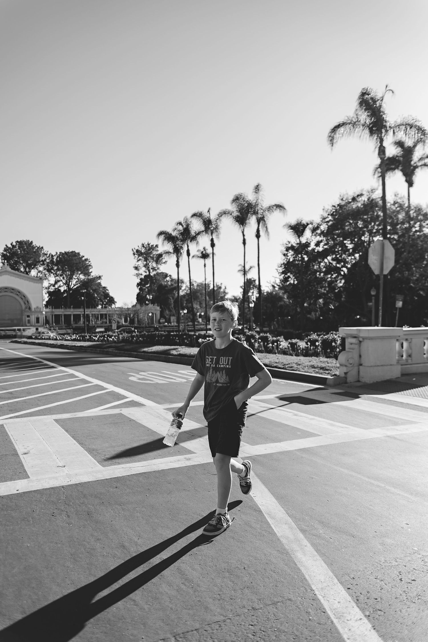 Black and white skateboarding sequence in urban parking lot with palm trees.