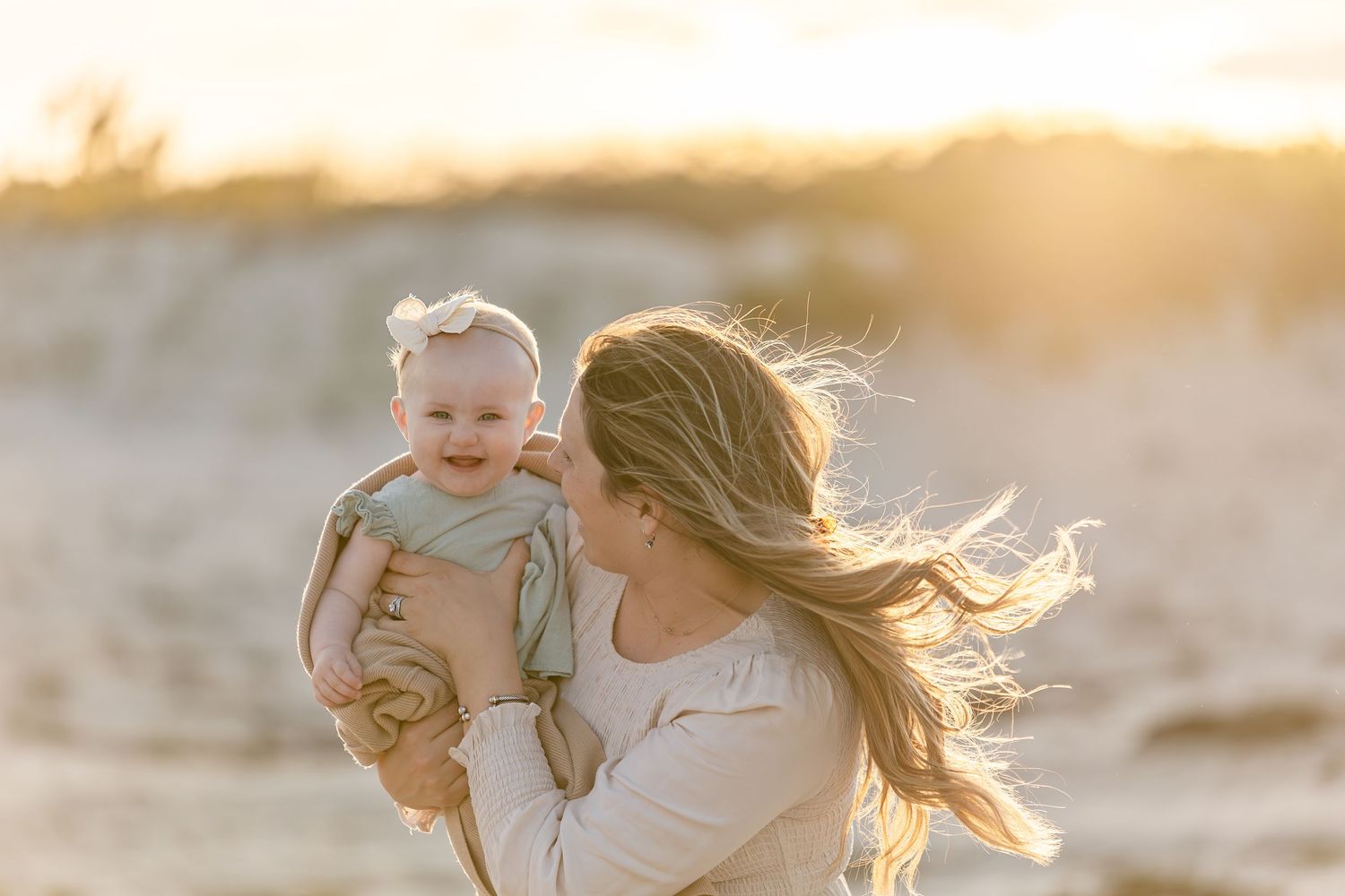 Sunset beach portrait with wind-blown hair and golden light.
