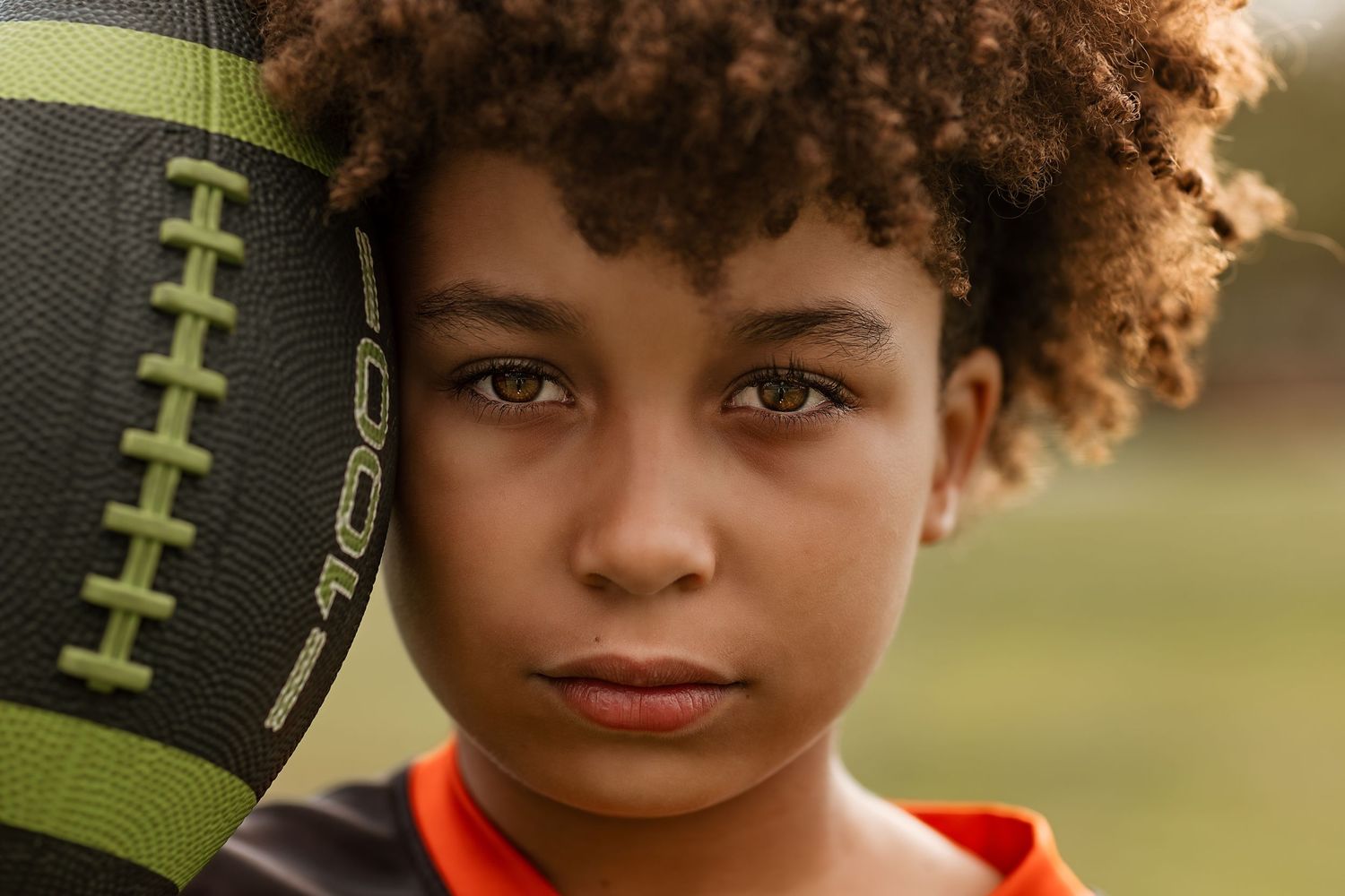 A child wearing a red shirt poses outdoors with a football in a series of connected portrait shots.