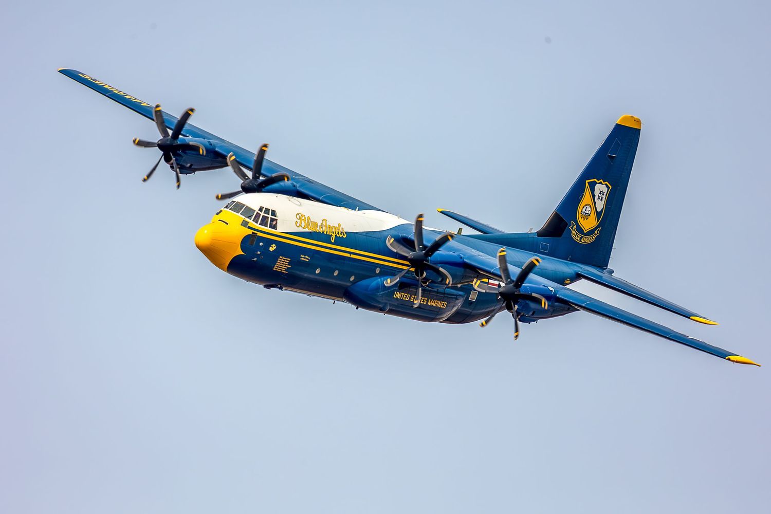 Blue Angels Fat Albert C-130J Hercules aircraft flying in blue and gold livery during an airshow performance.