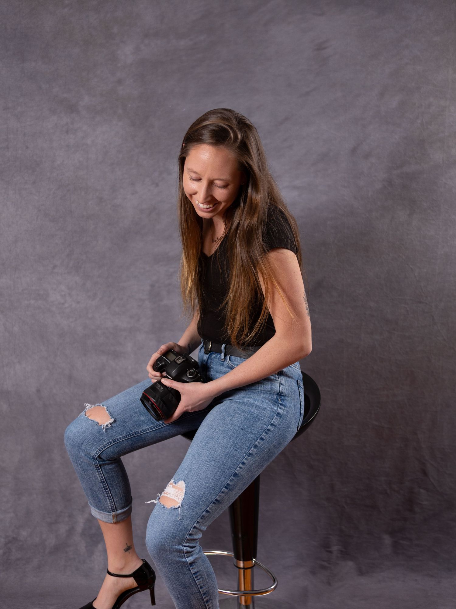 A series of four photos showing someone in jeans sitting casually on a wooden stool against a gray backdrop.