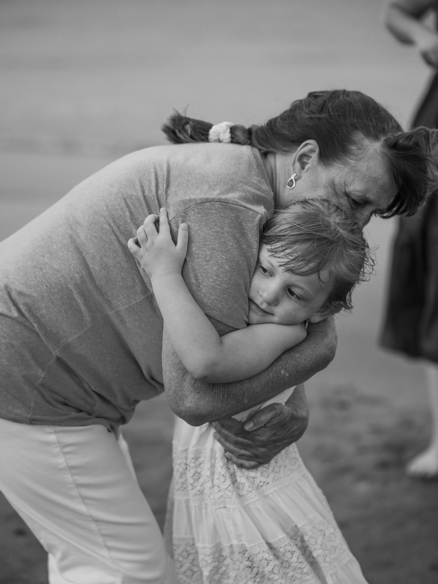 A tender black and white photograph captures an intimate embrace between two people sharing an emotional moment.