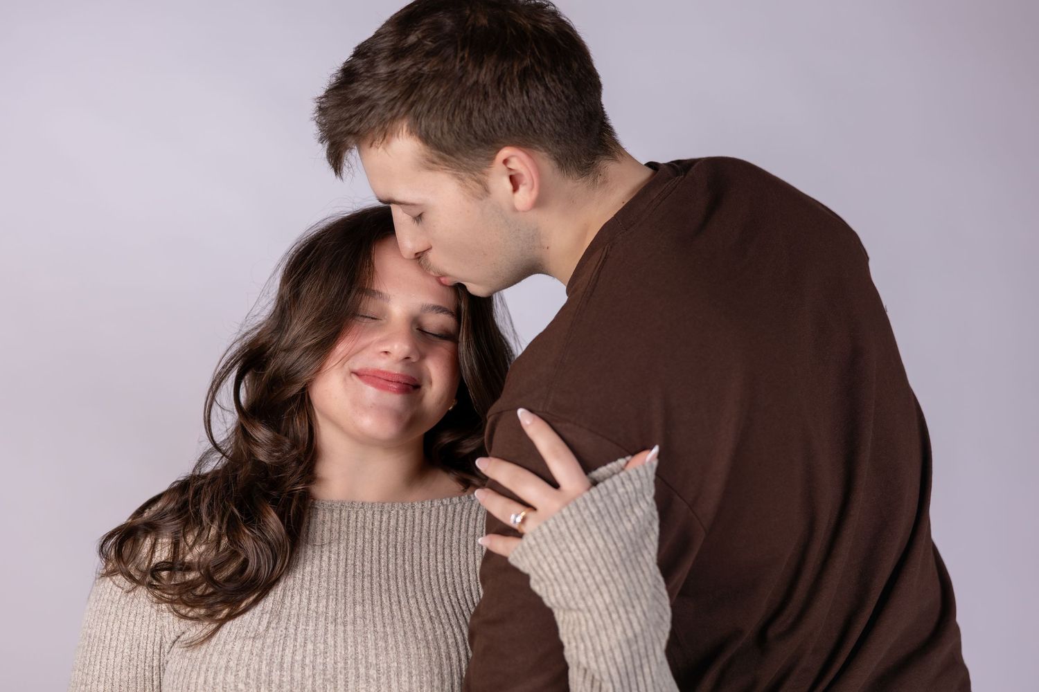 Romantic couple in casual sweaters embracing and smiling together in a series of intimate poses.