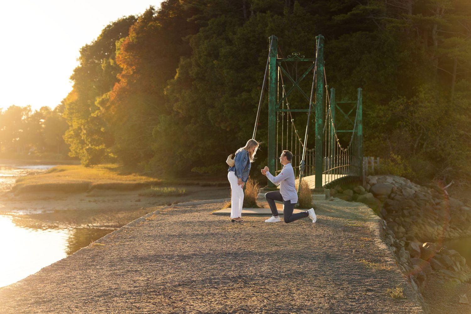 Silhouettes of people walking near playground equipment at sunset.