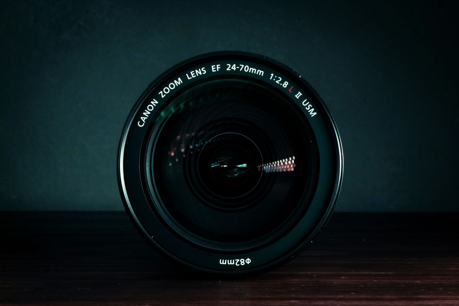 Close-up view of multiple camera lenses arranged in a dark moody setting on a wooden surface.