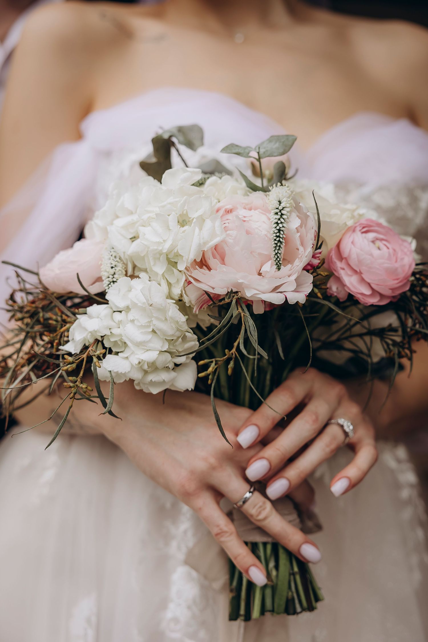 Close-up of bridal hands holding a soft pink and white peony bouquet, luxury wedding details in Atlanta.